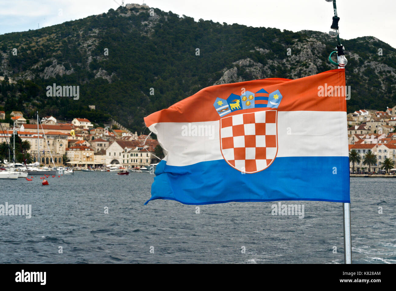 Kroatische Flagge, mit der Stadt Hvar auf dem Hintergrund. Ansicht vom Meer Stockfoto