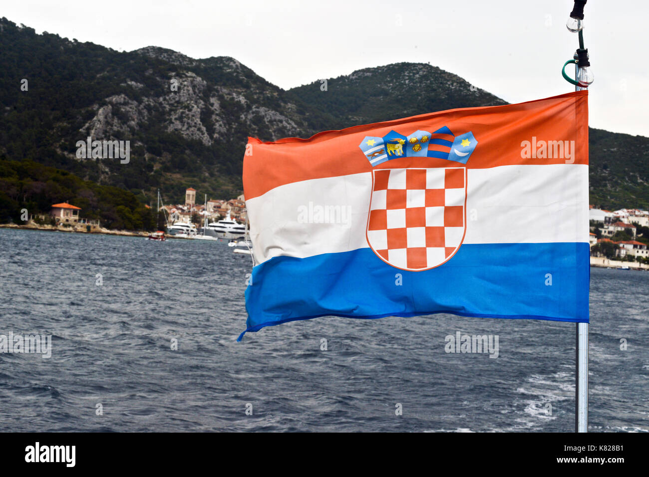 Kroatische Flagge, mit der Stadt Hvar auf dem Hintergrund. Ansicht vom Meer Stockfoto