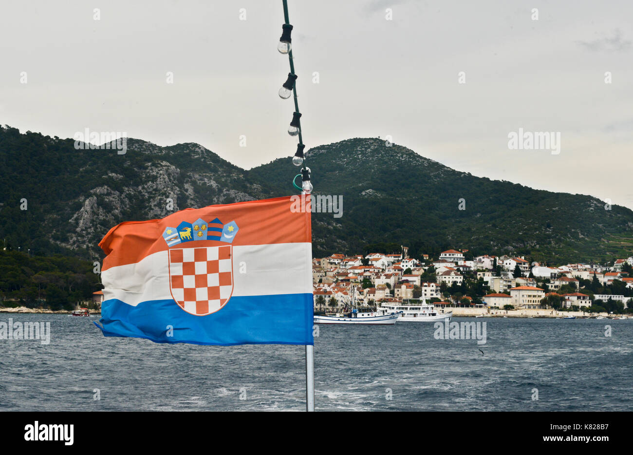 Kroatische Flagge, mit der Stadt Hvar auf dem Hintergrund. Ansicht vom Meer Stockfoto