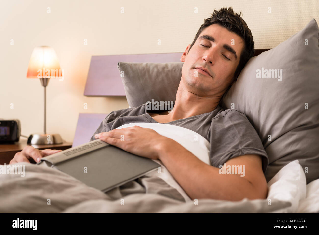 Junger Mann Einschlafen beim Lesen Stockfoto