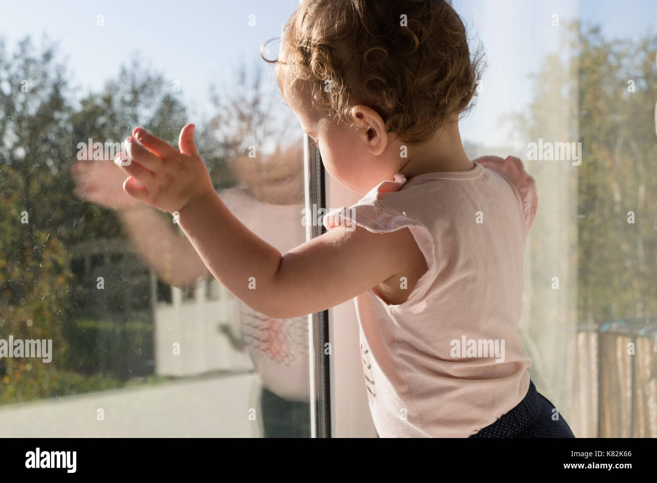 Kleines Kind durch das Fenster Stockfoto