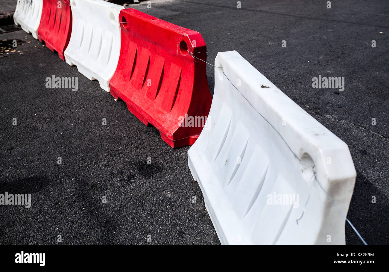 Rote und weiße Kunststoff Hindernisse blockiert die asphaltierte Straße Stockfoto