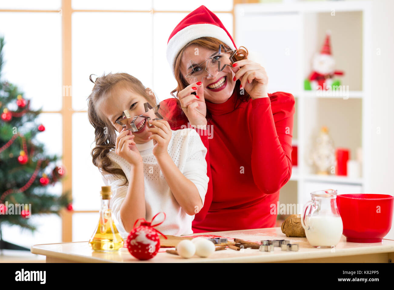 Mutter und Tochter backen Weihnachtsplätzchen. Kind und Frau Witze rund um mit Form für die Modellierung Stockfoto