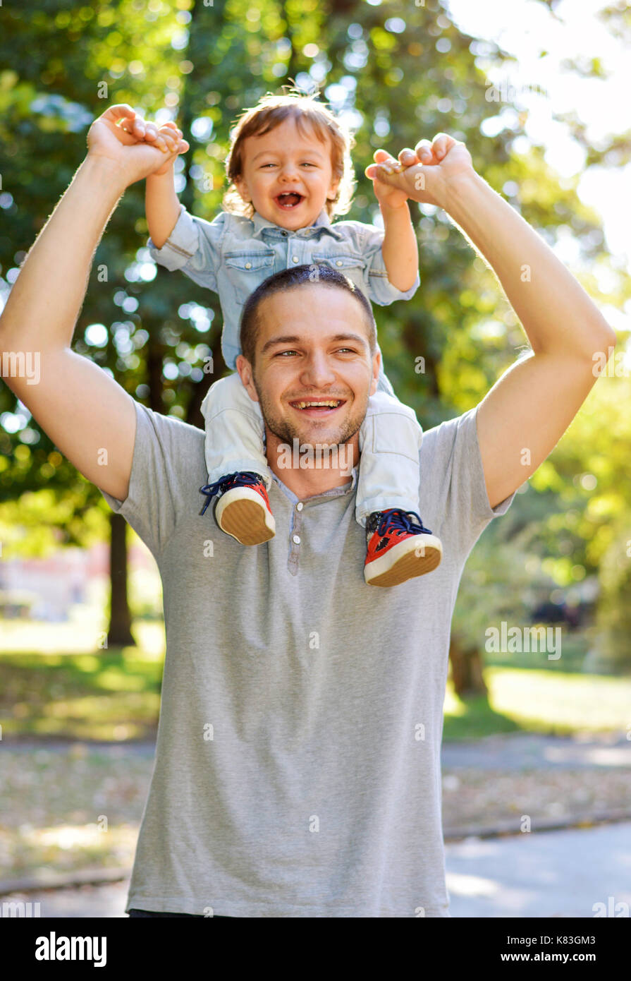 Glückliche junge Vater seinen Sohn in den Park Stockfoto