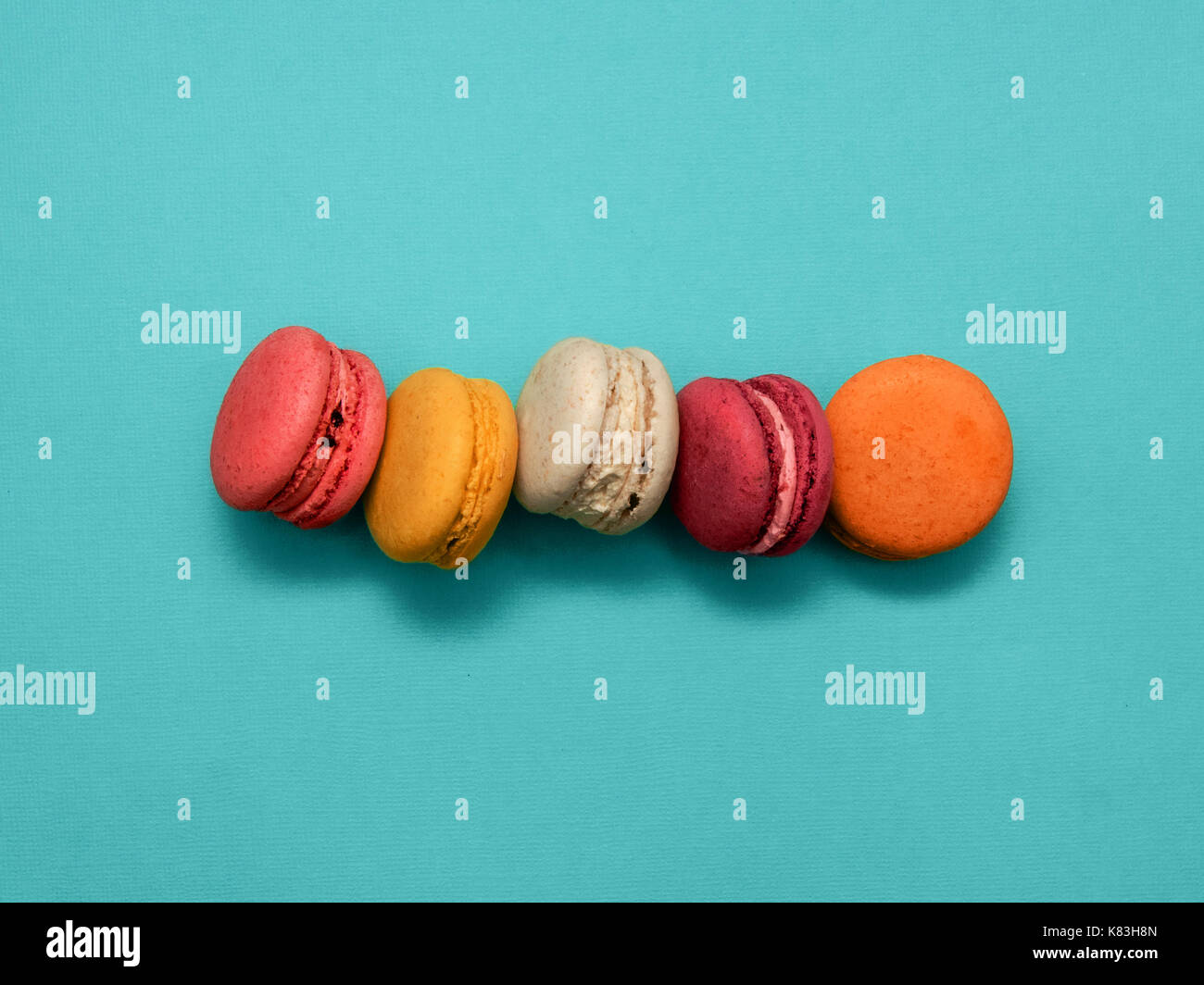 Makronen Draufsicht 5 süß und bunt Makronen oder Macaron auf Türkisfarbenem Hintergrund französische Dessert trendige helle Foto Hintergrund mit Platz für t Stockfoto