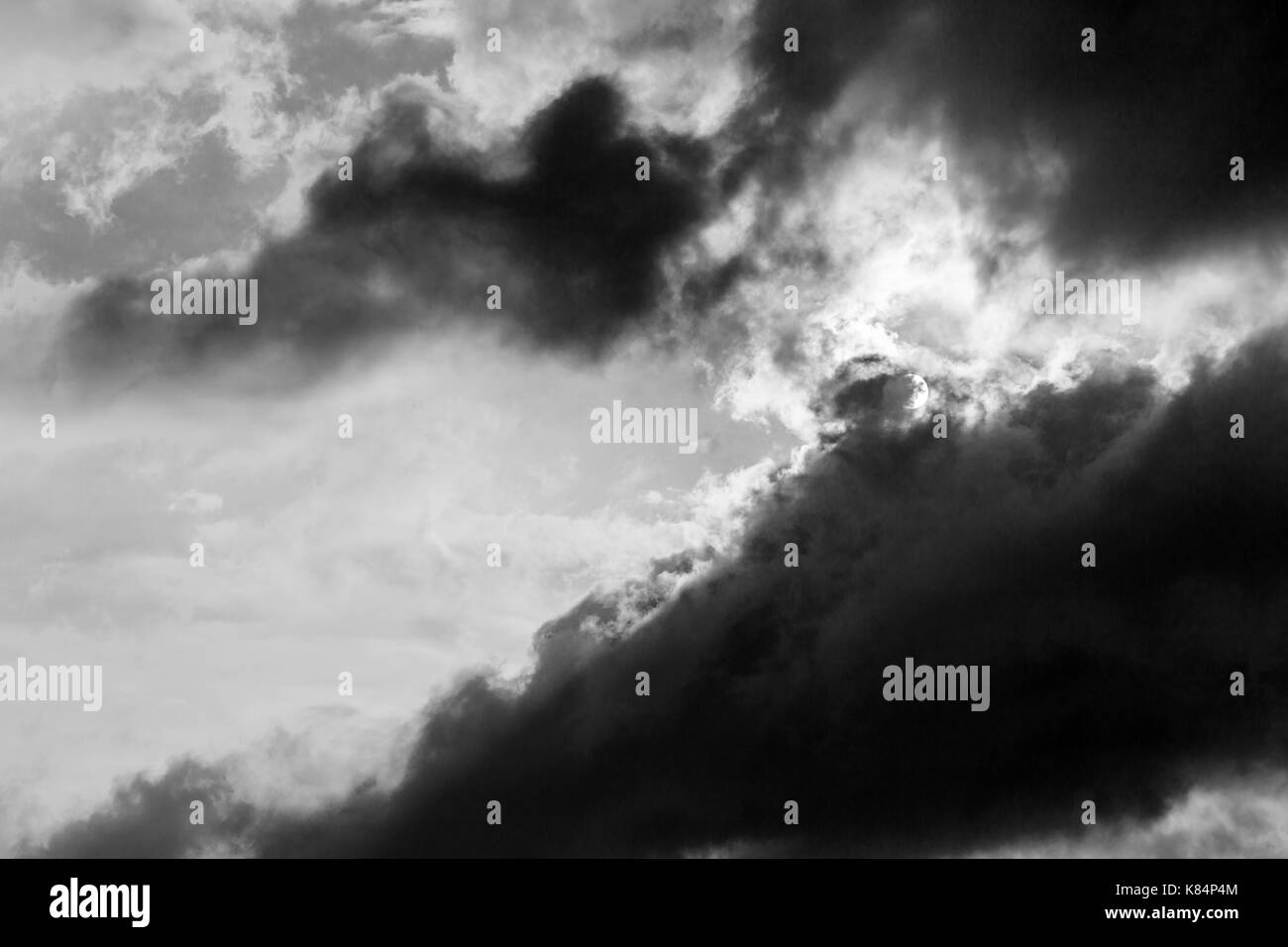 Eine enge Sicht auf einige Moody und große Wolken mit der Hälfte der Sonne durch sie abgedeckt Stockfoto