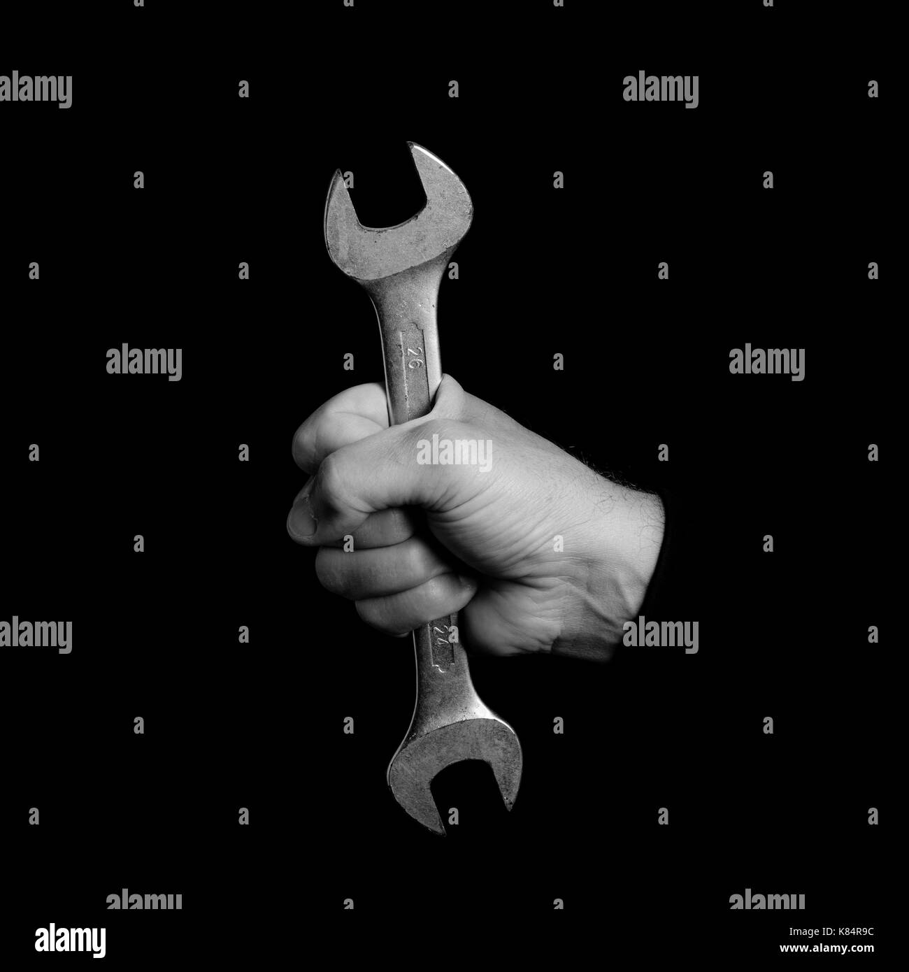 Schraubenschlüssel - Werkzeuge in der Hand eines Mannes - schwarz-weiß Foto Stockfoto