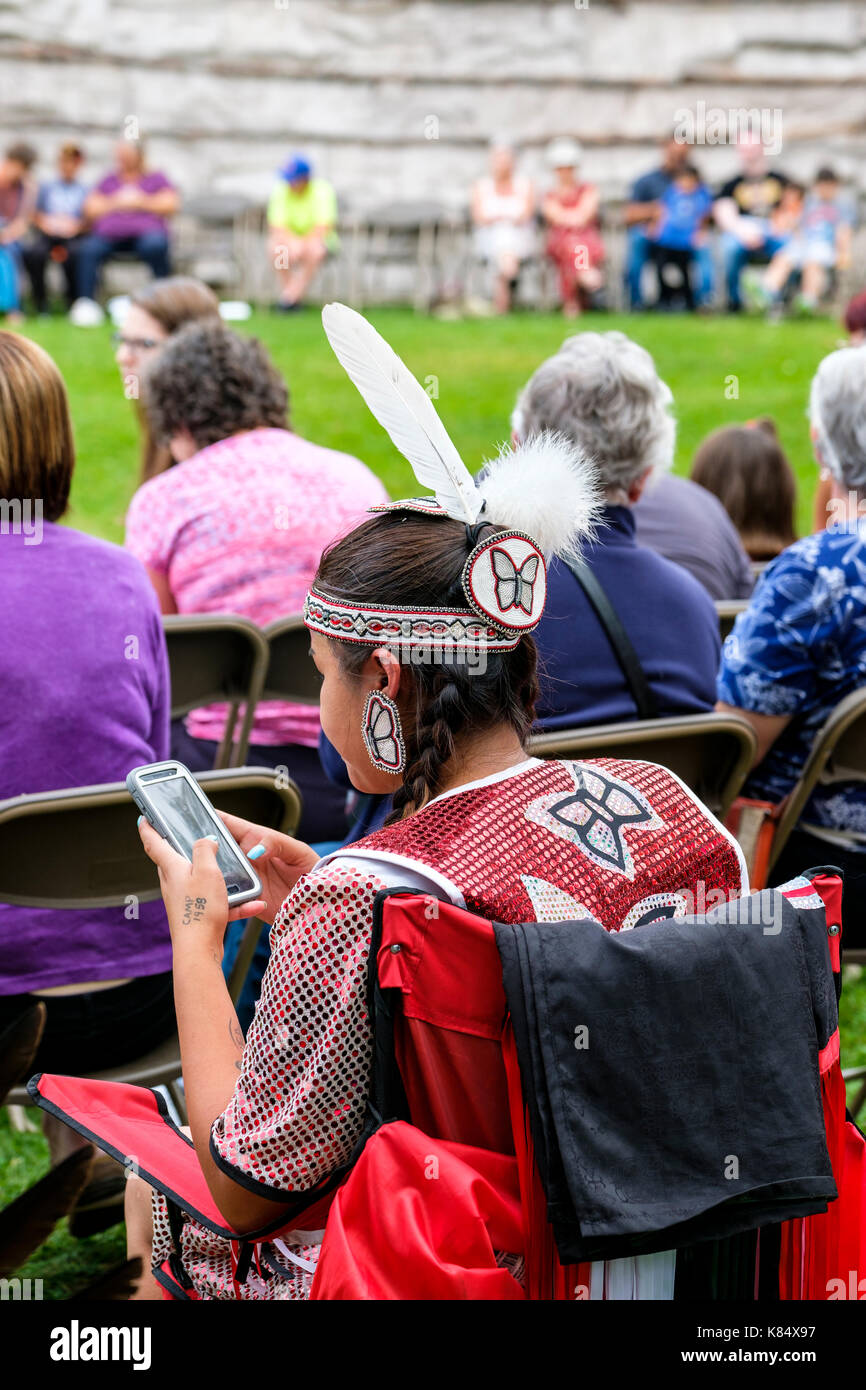 Kanadische Ureinwohner, First Nations, gebürtige Ojibwe/Chippewa-Ureinwohnerin überprüft ihr Handy während einer Pow Wow-Feier, London, Ontario, Kanada. Stockfoto