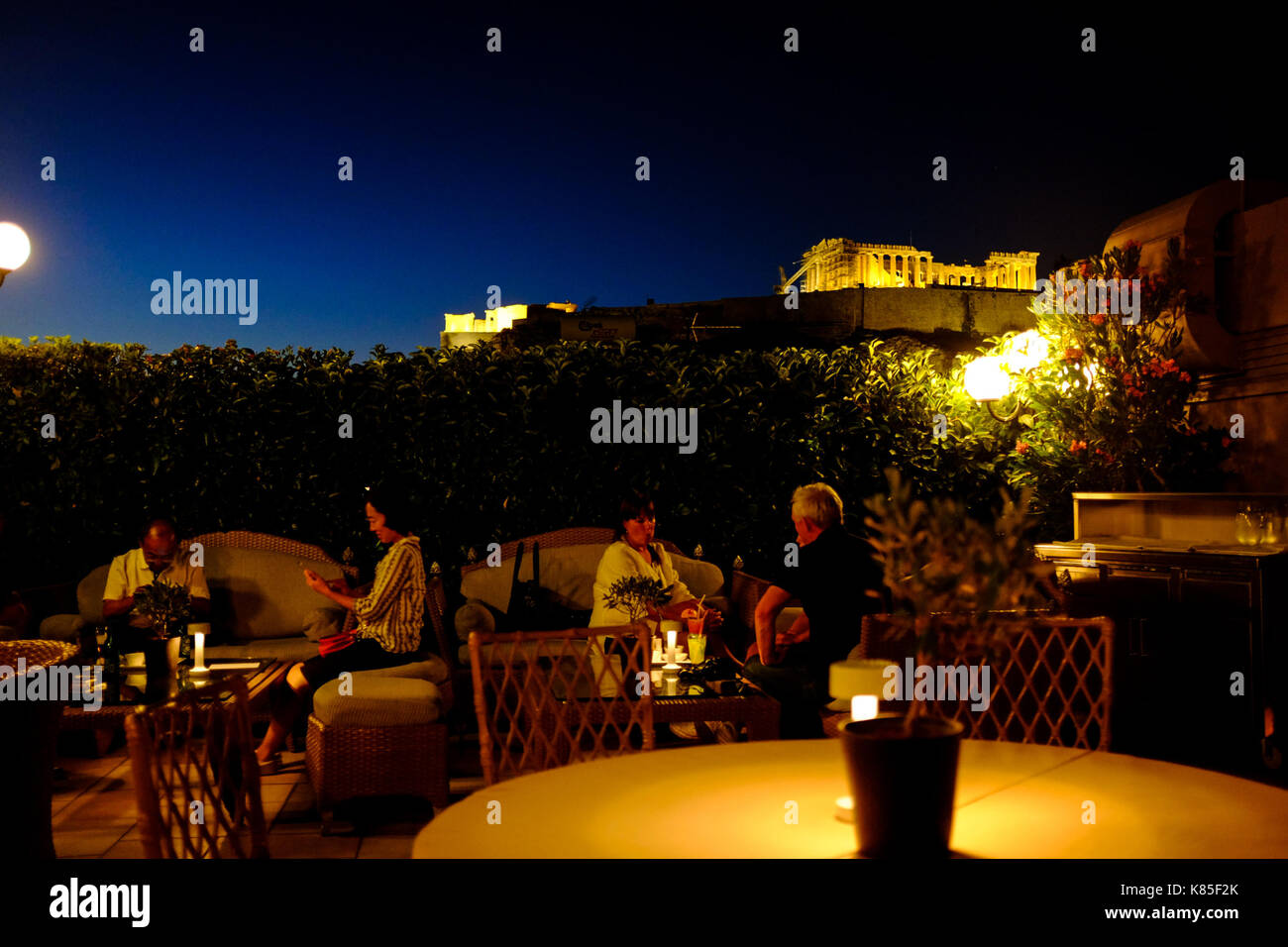 Die Menschen essen und Vermischen und Blick auf den Parthenon von oben ein Restaurant auf der Dachterrasse in Athen, Griechenland, 2017. Stockfoto
