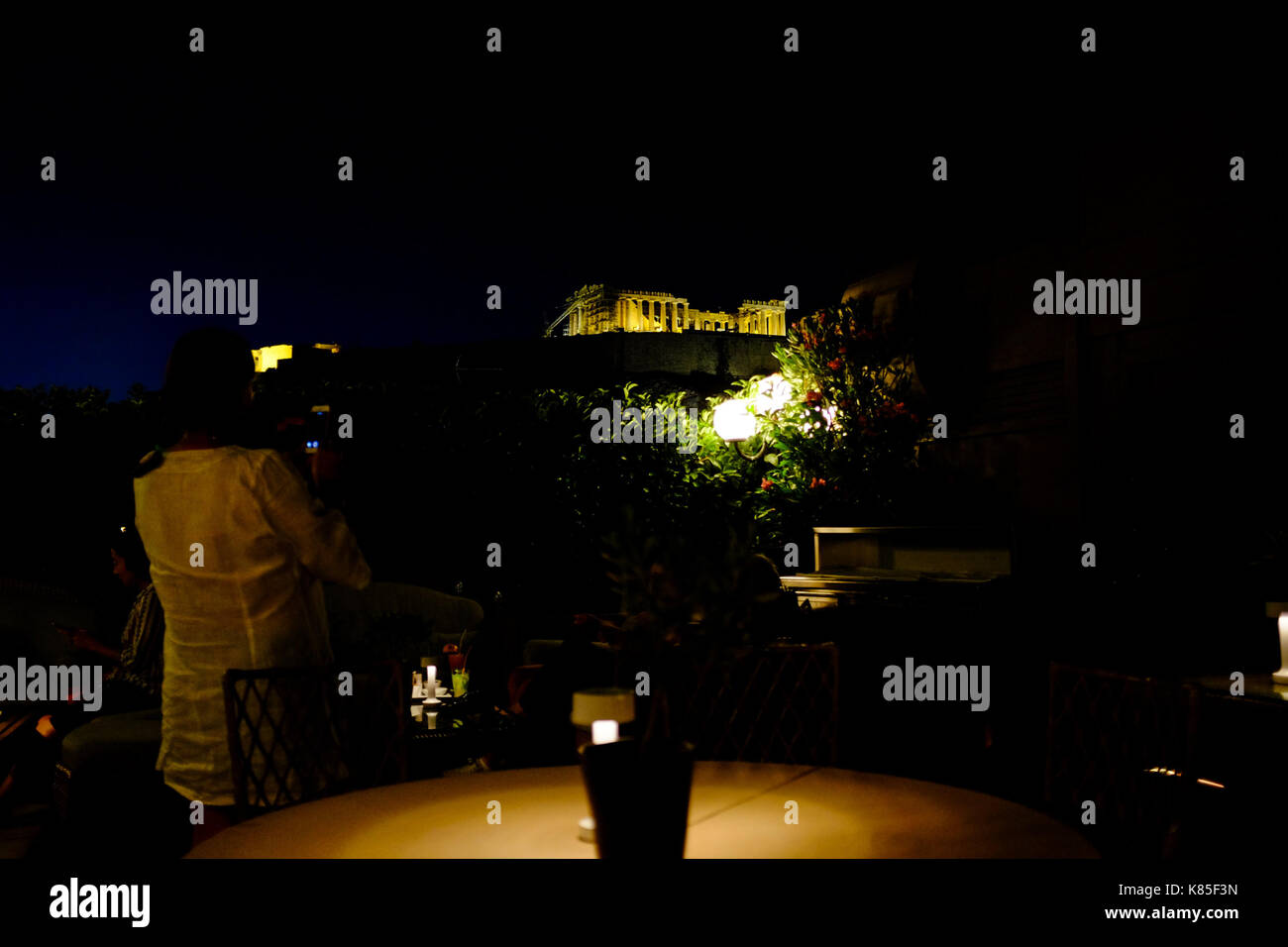 Die Menschen essen und Vermischen und Blick auf den Parthenon von oben ein Restaurant auf der Dachterrasse in Athen, Griechenland, 2017. Stockfoto