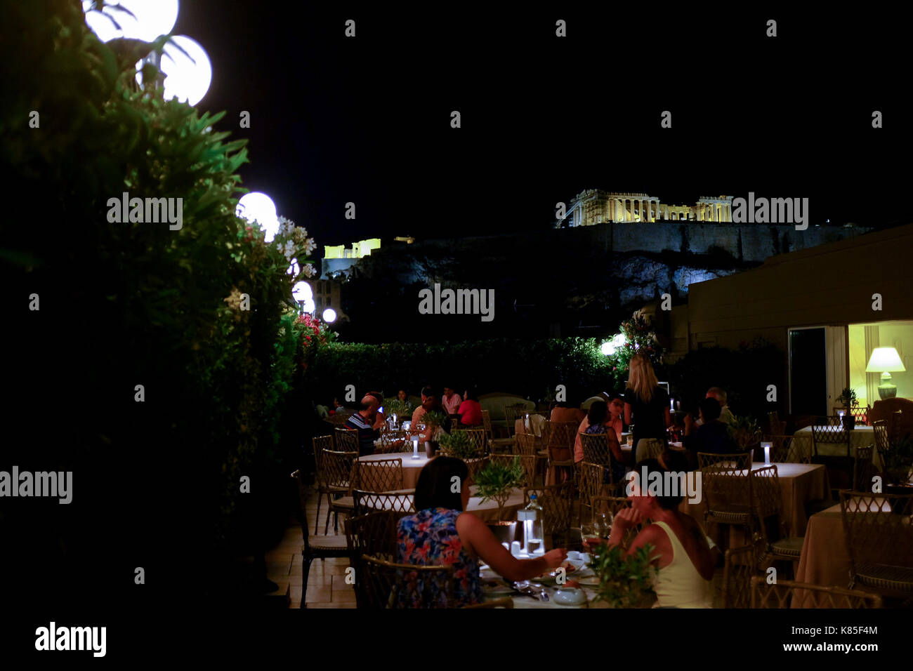 Die Menschen essen und Vermischen und Blick auf den Parthenon von oben ein Restaurant auf der Dachterrasse in Athen, Griechenland, 2017. Stockfoto