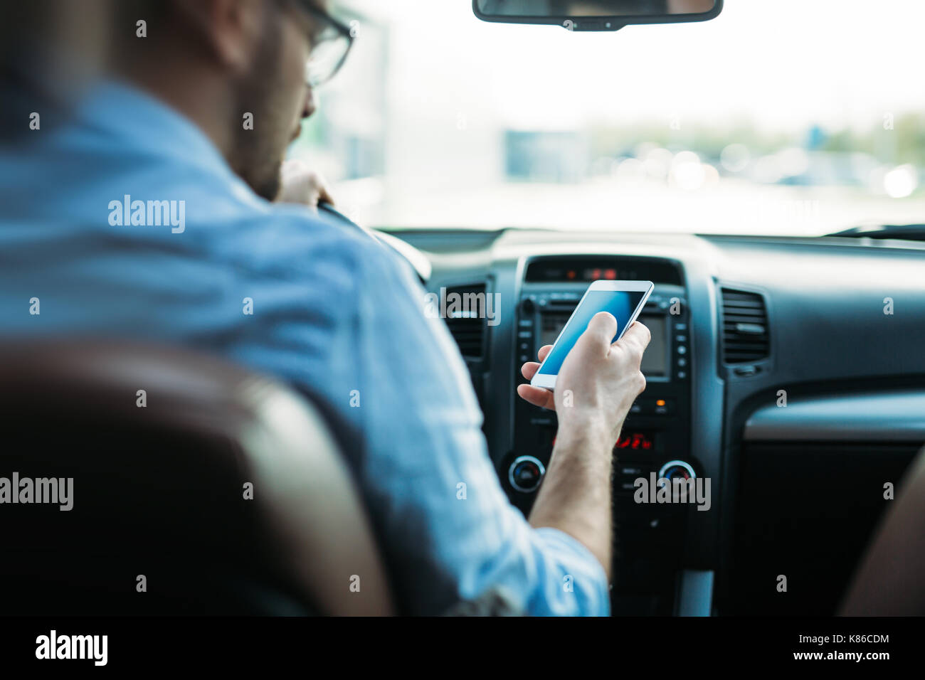 Mann mit Handy während der Fahrt das Auto Stockfoto