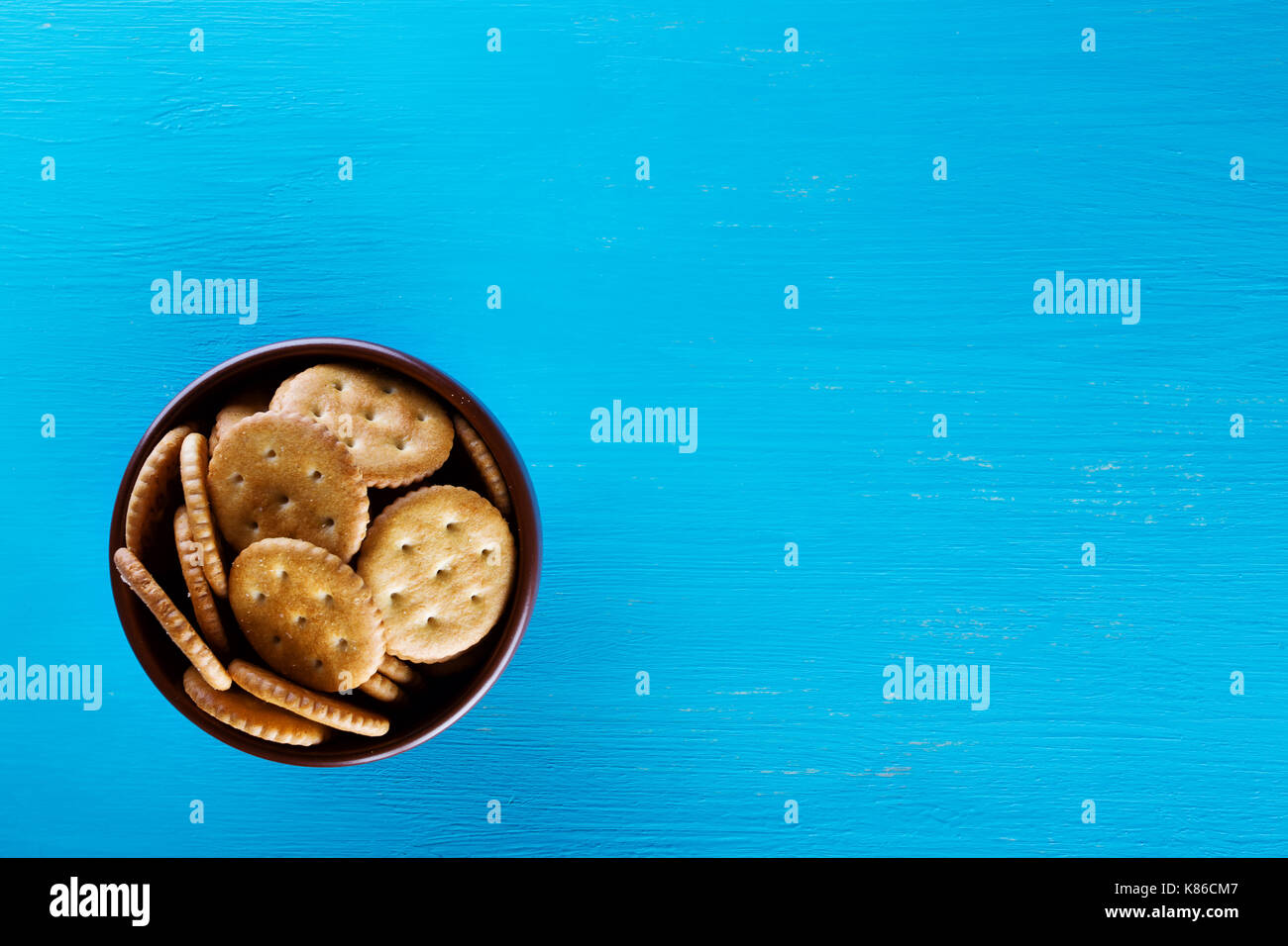 Schüssel mit knusprigen Kekse auf blauem Hintergrund. Blick von oben. Das Konzept der gesunden Ernährung. Stockfoto