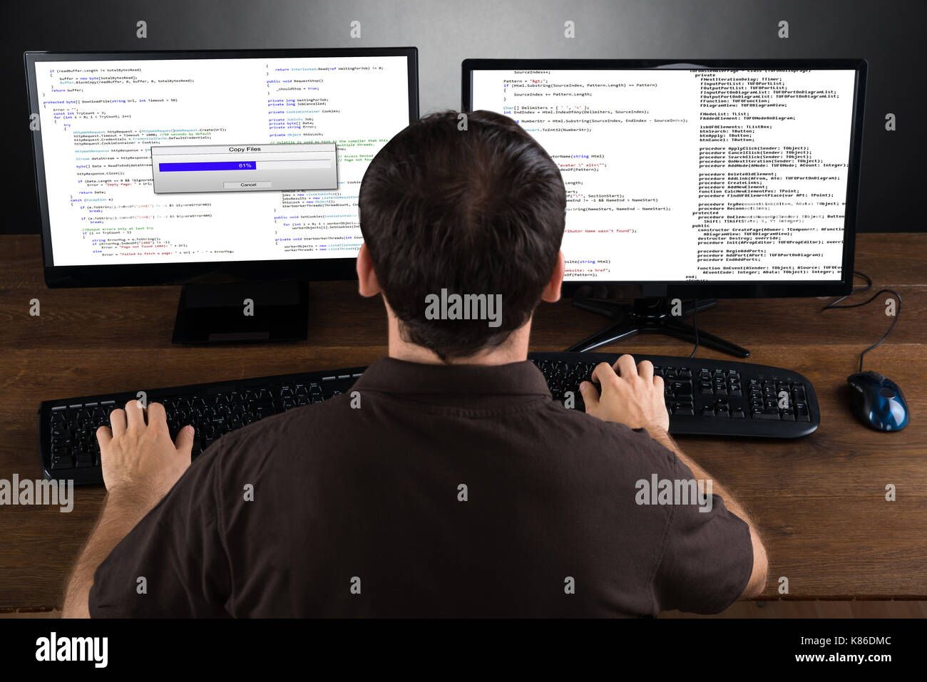 Junger Mann Programmierung Code auf den Computern am Schreibtisch Stockfoto