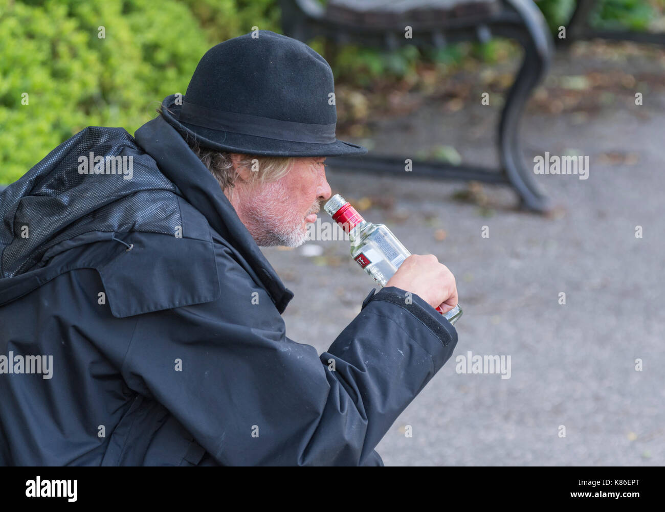 Mann draußen trinken in der Tageszeit, die Obdachlosen zu, im Süden von England, UK. Mann ertrinken seine Sorgen. Stockfoto