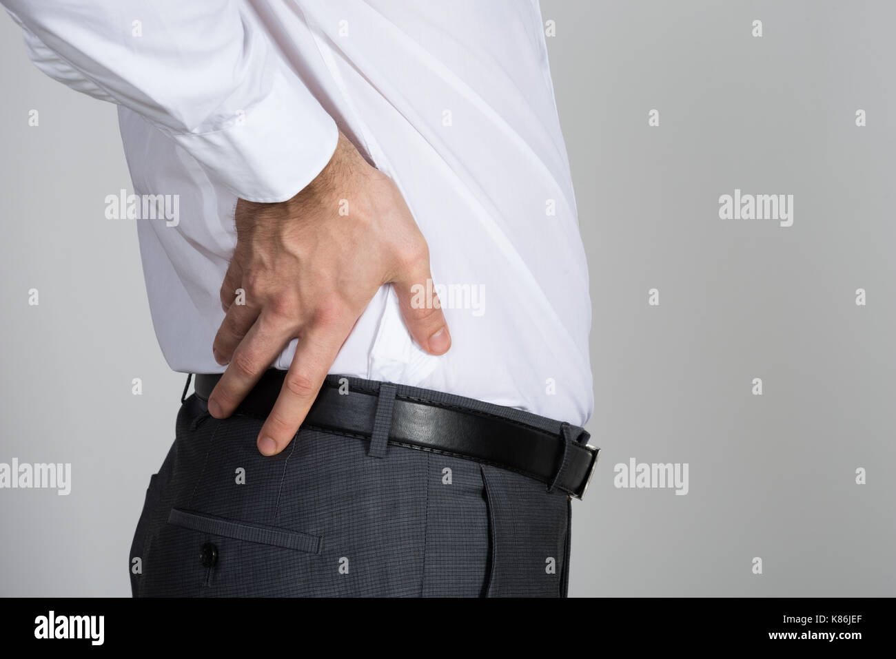 Ansicht der Rückseite des Unternehmer leiden unter Rückenschmerzen vor weißem Hintergrund Stockfoto