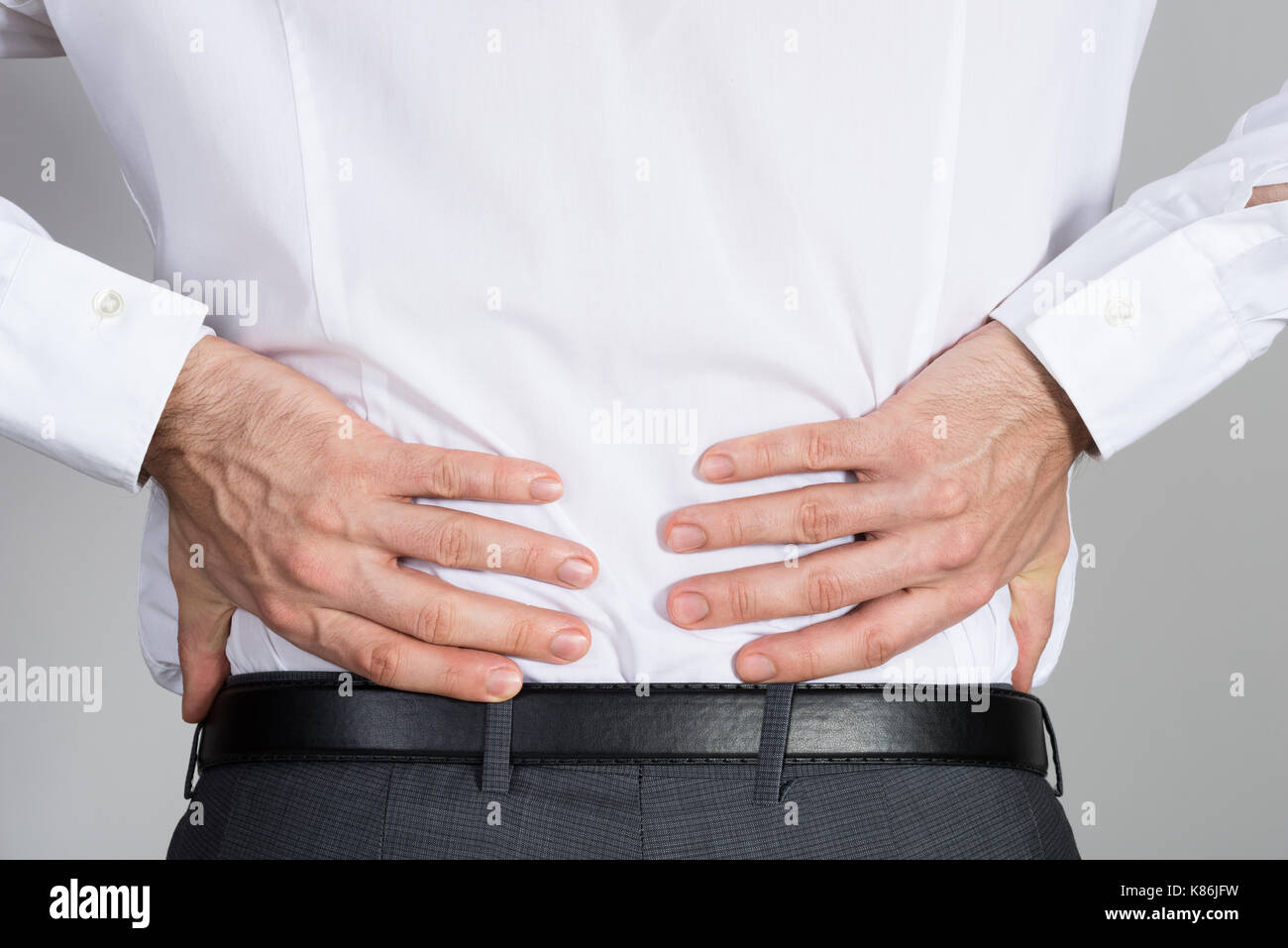 Ansicht der Rückseite des Unternehmer leiden unter Rückenschmerzen vor weißem Hintergrund Stockfoto