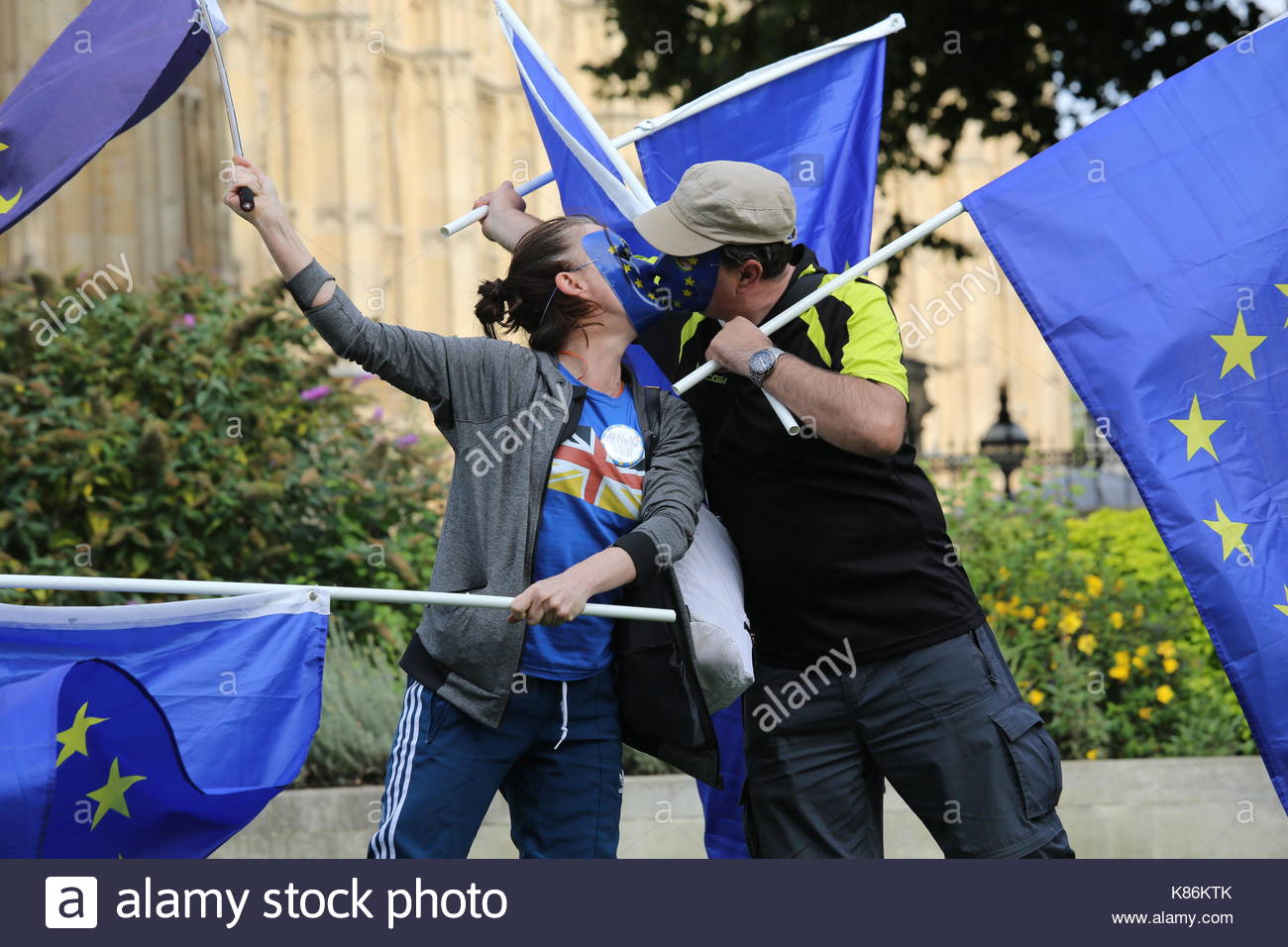 Zwei maskierte, Küssen EU-Befürworter Lager Flaggen in Unterstützung der EU in Westminster. Credit: reallifephotos/Alamy Stockfoto