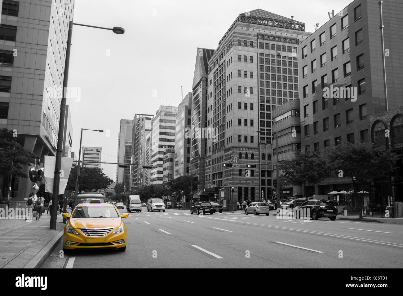 Südkorea. Taxi in der Farbe Gelb in der Ampel mit dem Bau- und dem Auto im Hintergrund Stockfoto