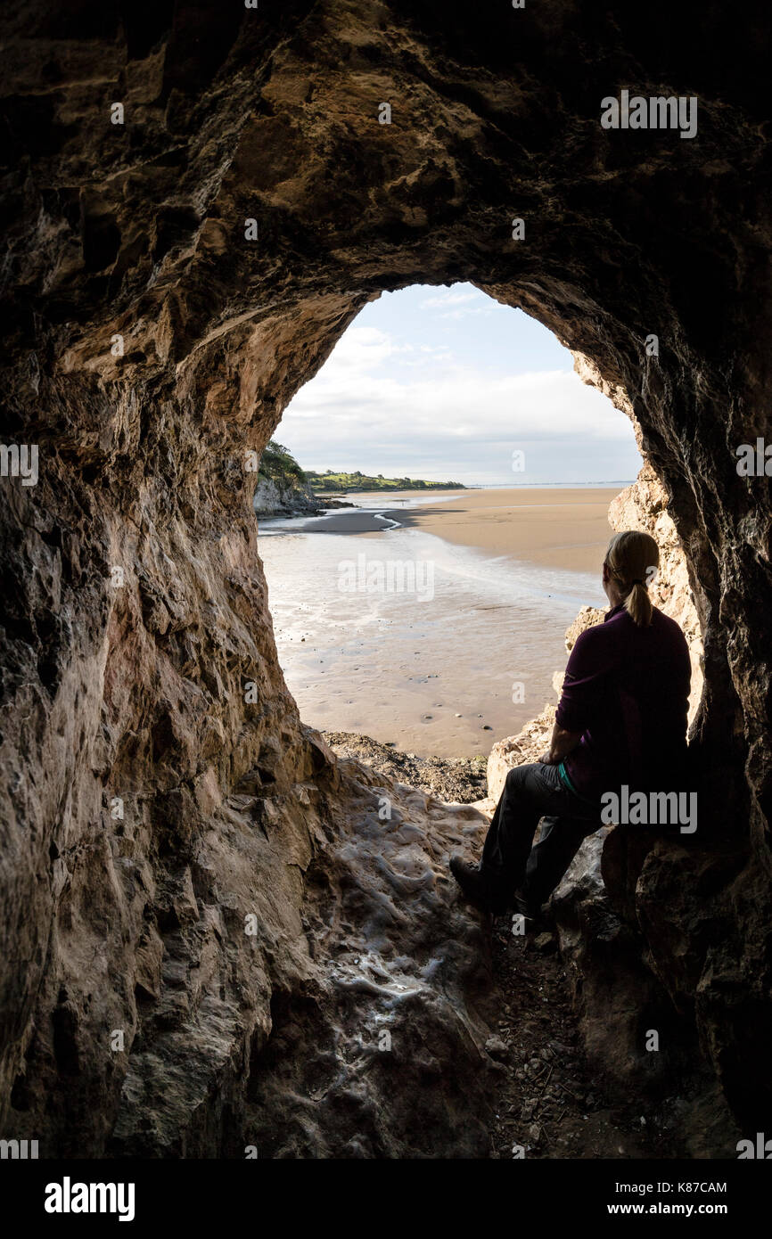 Wanderer genießen den Blick von der Innenseite der Bucht Höhle über den Sand der Morecambe Bay, Silverdale, Lancashire, Großbritannien Stockfoto