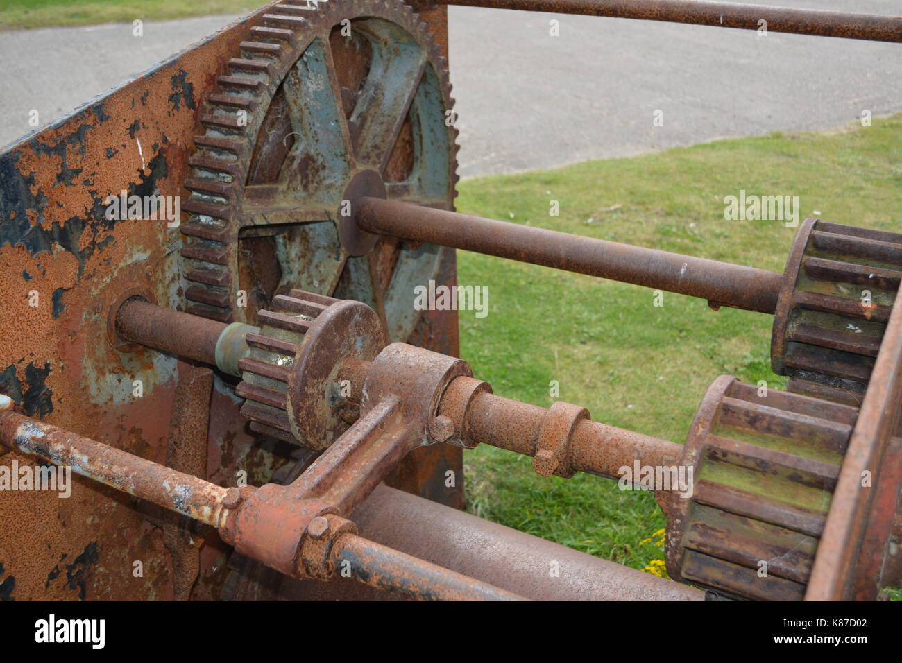 Nahaufnahme von alten verrosteten und abgenutzten Maschinen re industrielles Erbe Zahnräder und Räder auf grasbewachsenen Oberfläche in der Nähe von Nigg Scotland Cromarty Firth Stockfoto