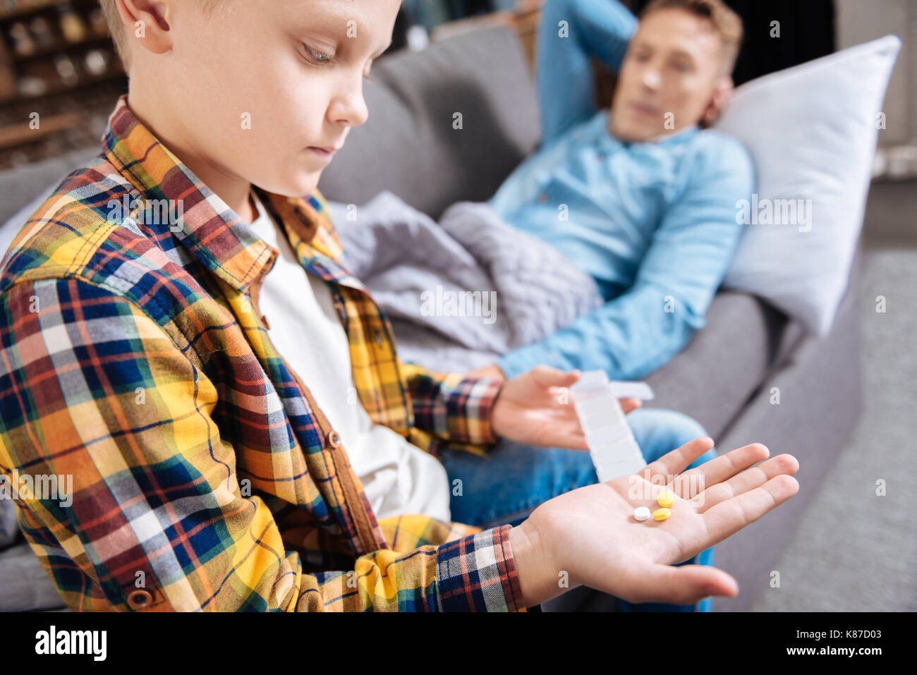 Pre-teen Boy holding Pillen für seinen kranken Vater Stockfoto