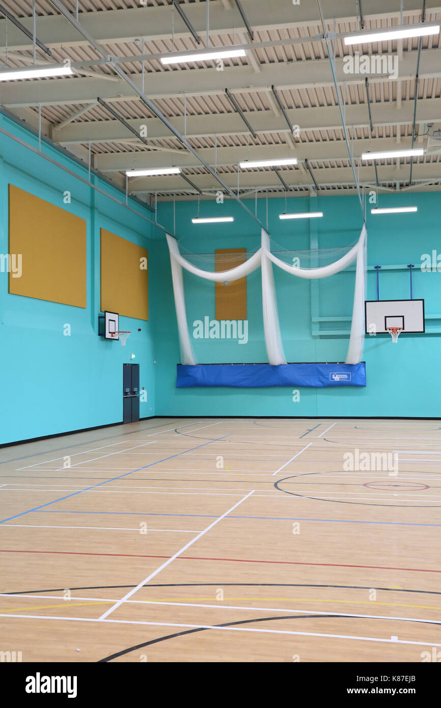 Sporthalle in einer neuen britischen Secondary School. Zeigt basket ball Ziele und Cricket Netze Stockfoto