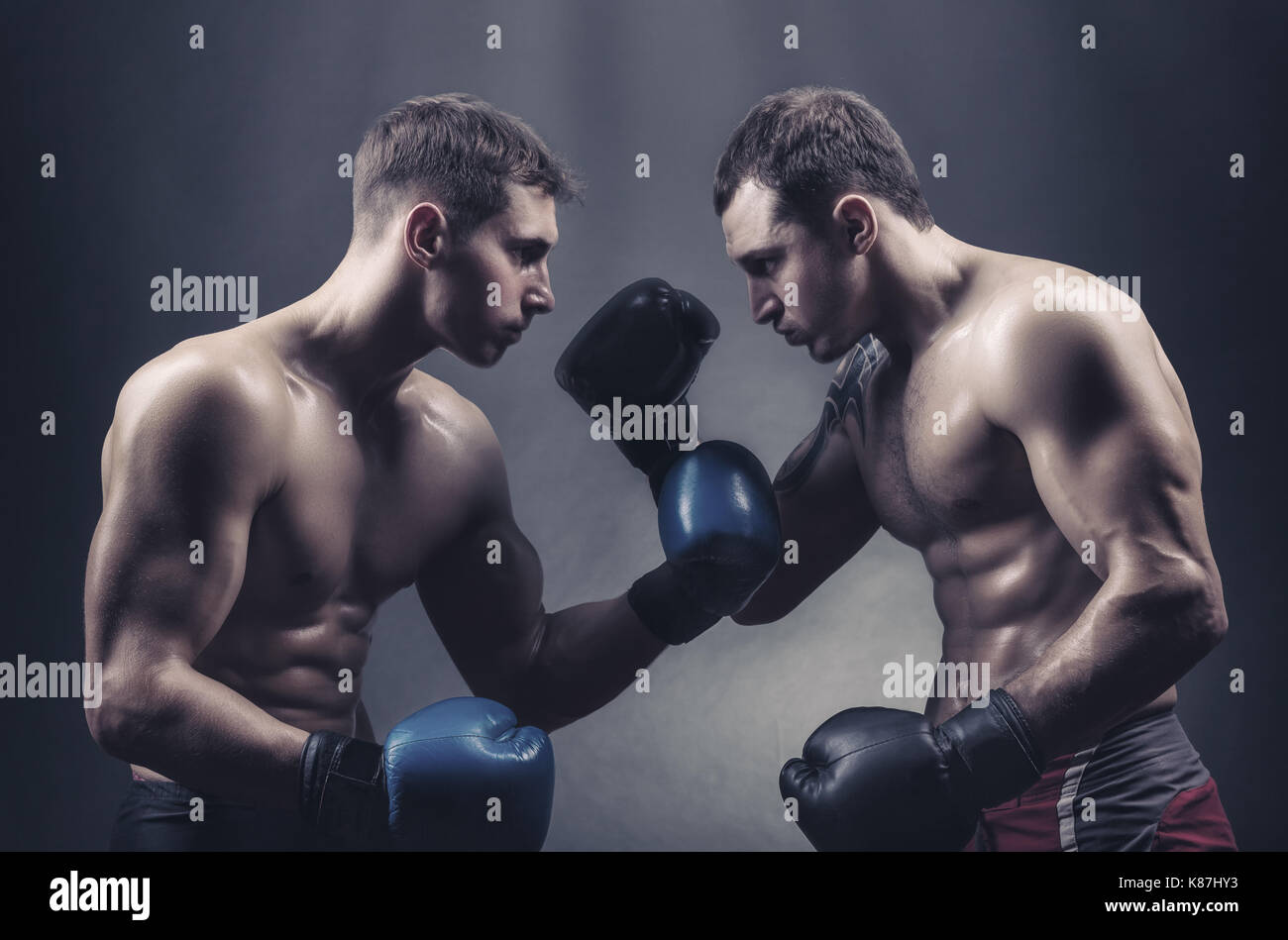 Zwei Boxer in Boxhandschuhe mit Blicke gegen einen dunklen Hintergrund Stockfoto