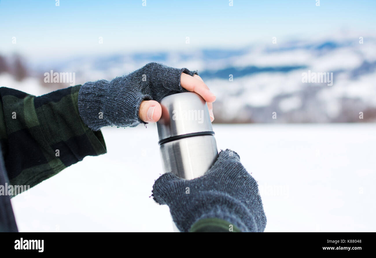 Mann mit Thermosflasche auf den verschneiten Berg Stockfoto