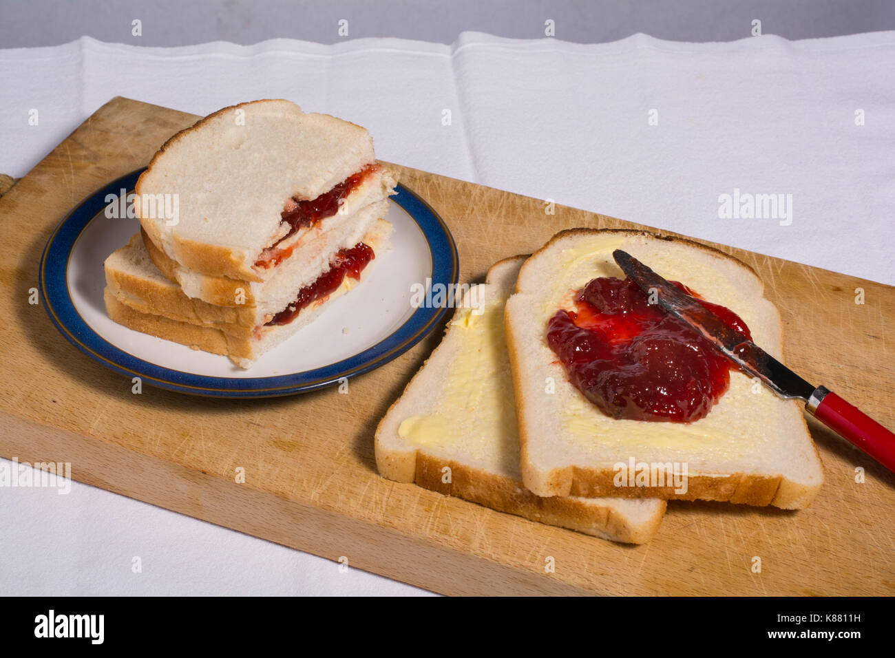 Grob und unhöflich Altmodische jam Sandwich. Weiß geschnitten Brot und Erdbeermarmelade Stockfoto