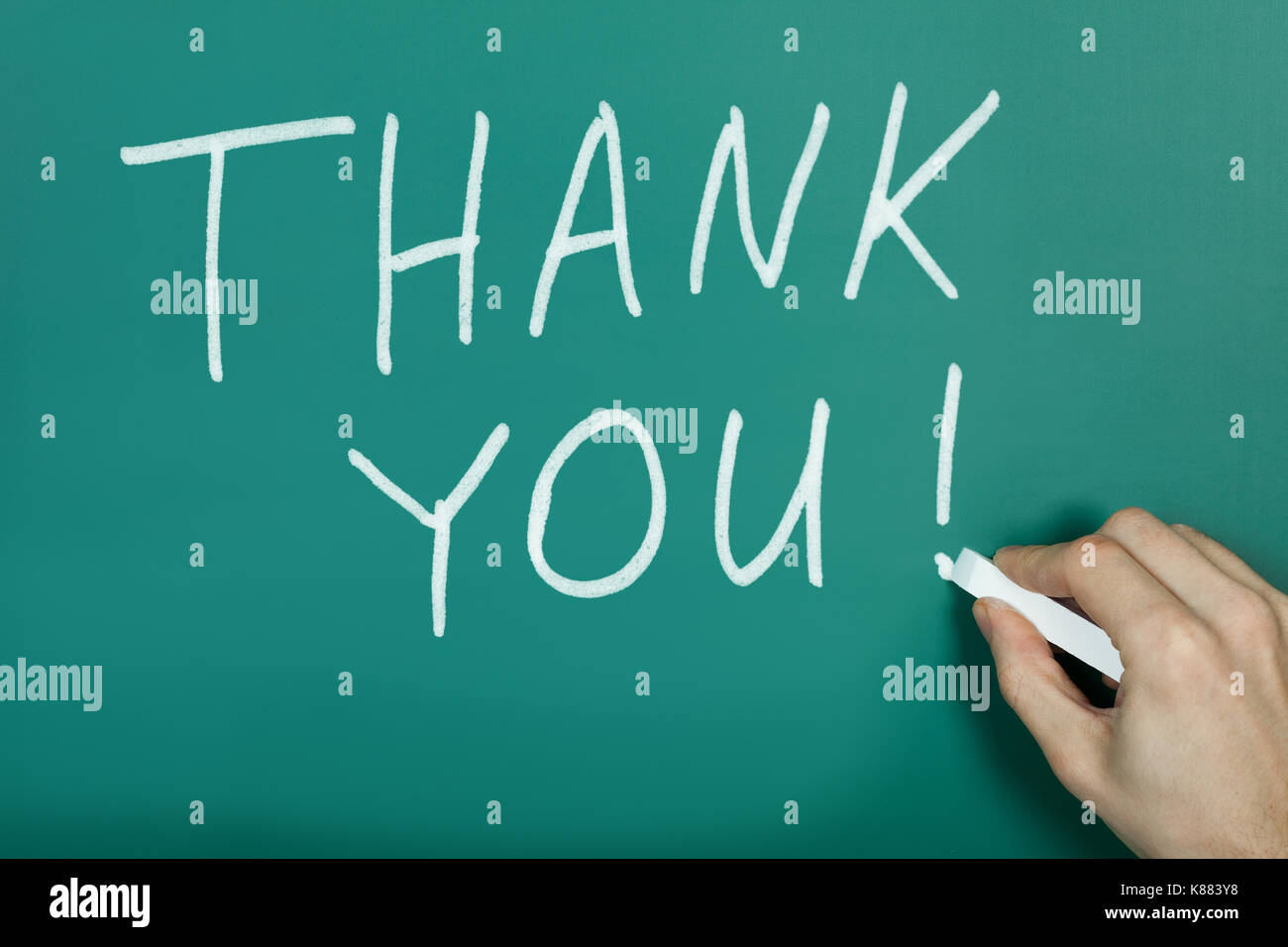 Nahaufnahme der Hand schreiben mit Kreide den Text Danke auf grüner Tafel Stockfoto