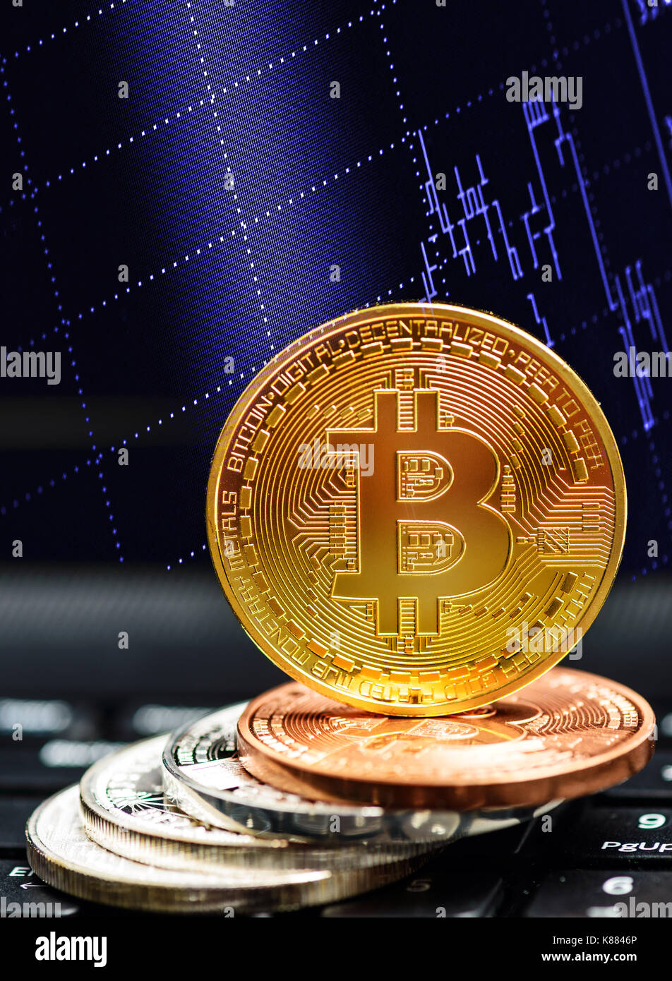 Bitcoin Geschäftskonzept. Golden bitcoin auf schwarz Tastatur mit aktienchart Stockfoto