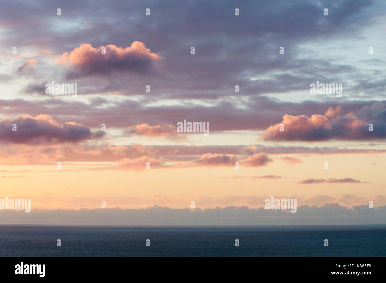 Blick vom Land über das Meer, bis zum Horizont. Sonnenuntergang Licht auf den Wolken. Stockfoto