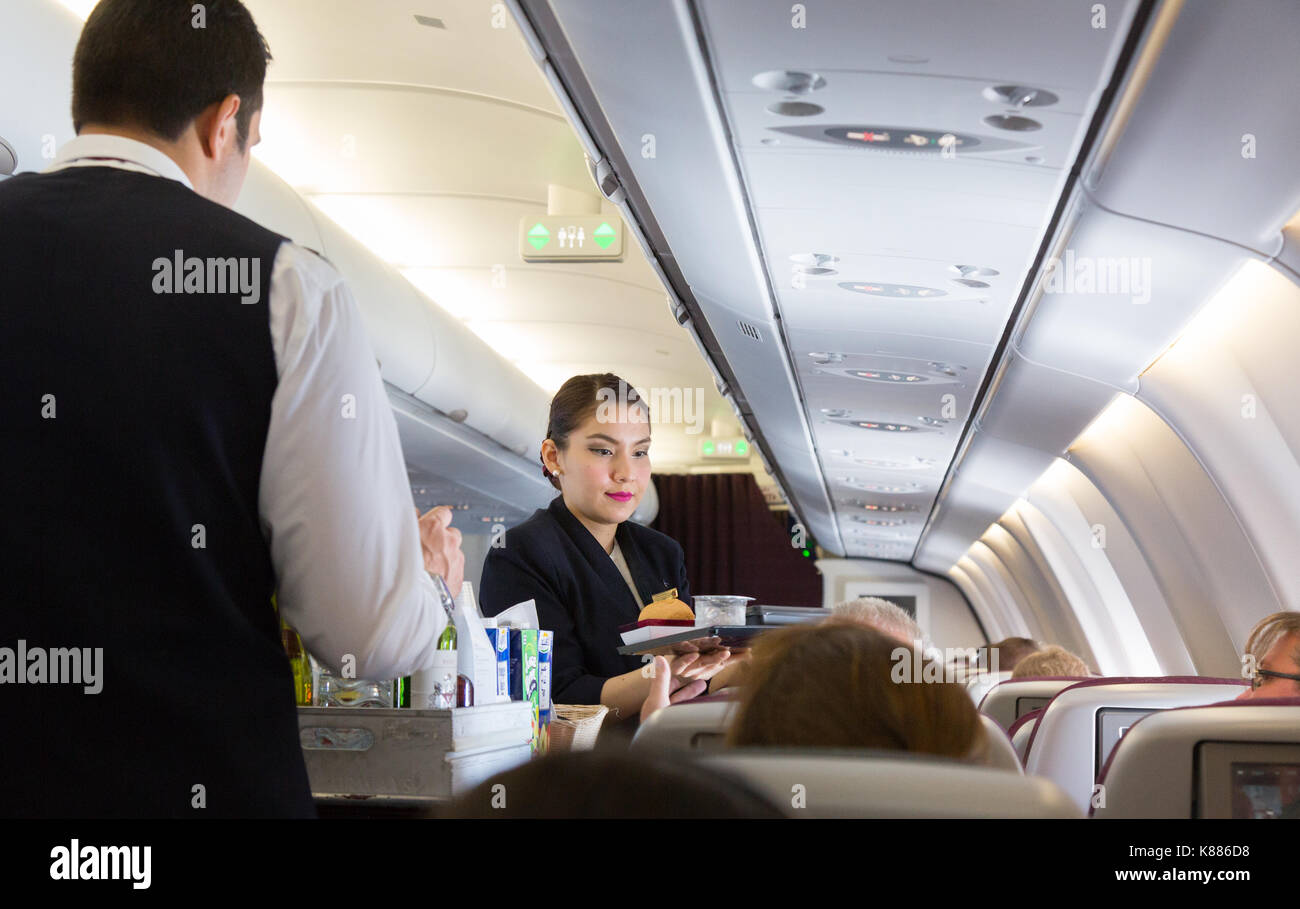 Cabin Crew arbeiten - eine Stewardess serviert Essen, Qatar Airways A330 Flug von Malediven zu Doha, Stockfoto