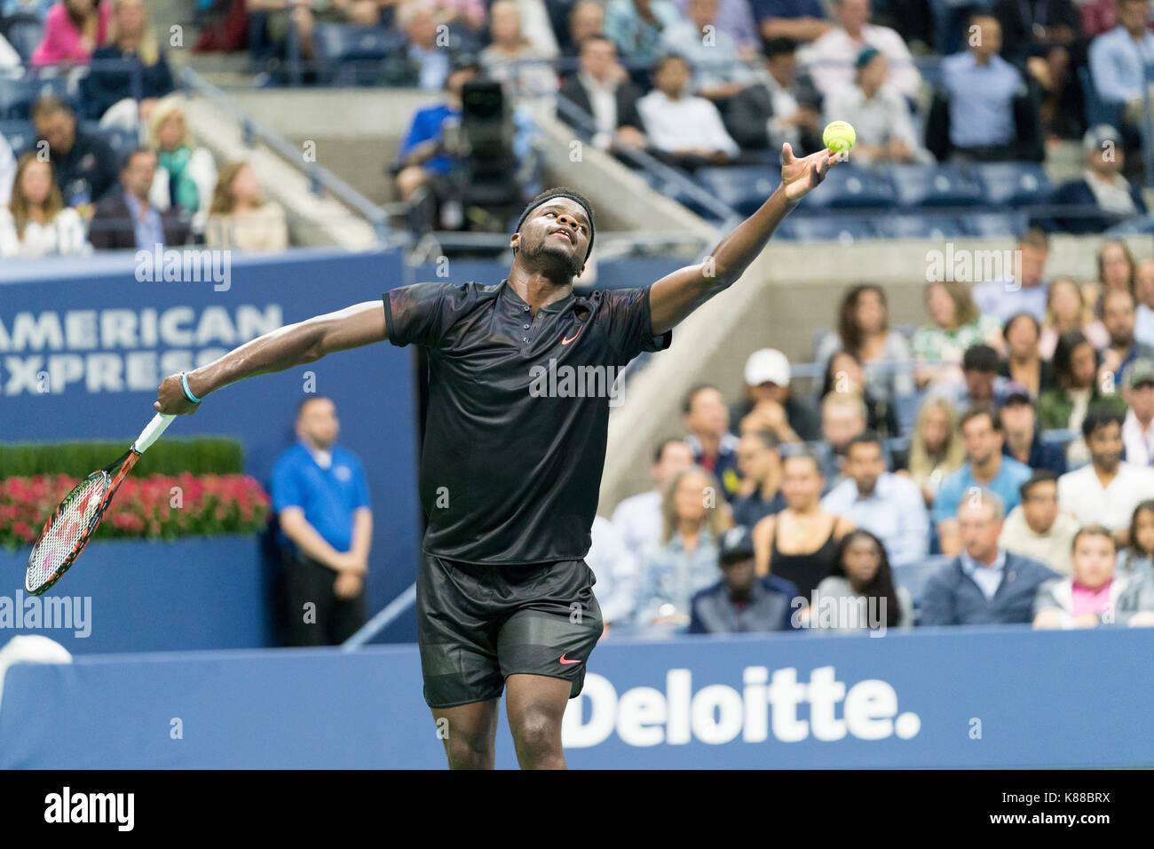 New York, NY, USA - 29. August 2017: Frances Tiafoe der USA dient während der Match gegen Roger Federer aus der Schweiz bei uns Offene Meisterschaften an Billie Jean King National Tennis Center Stockfoto