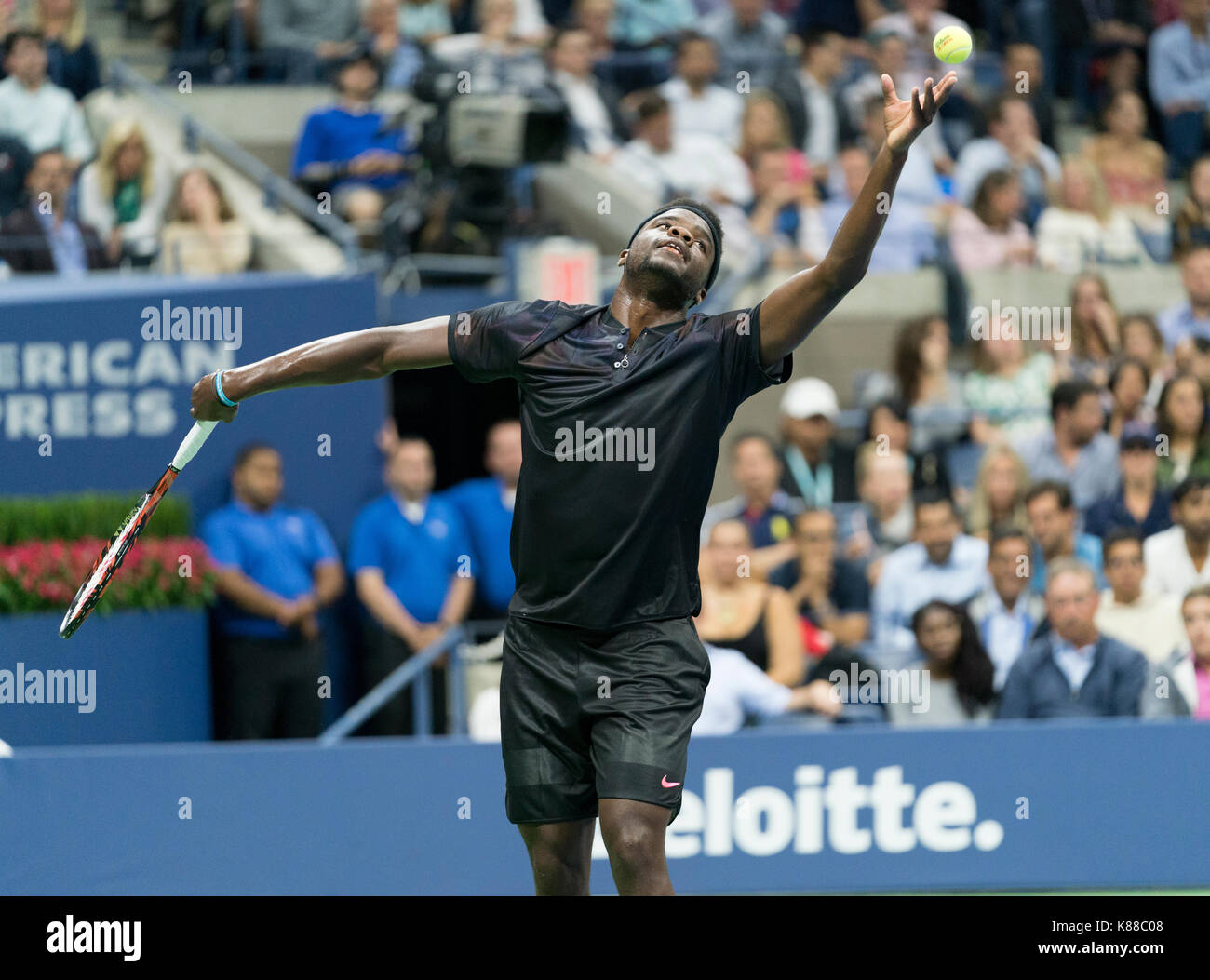 New York, NY, USA - 29. August 2017: Frances Tiafoe der USA dient während der Match gegen Roger Federer aus der Schweiz bei uns Offene Meisterschaften an Billie Jean King National Tennis Center Stockfoto