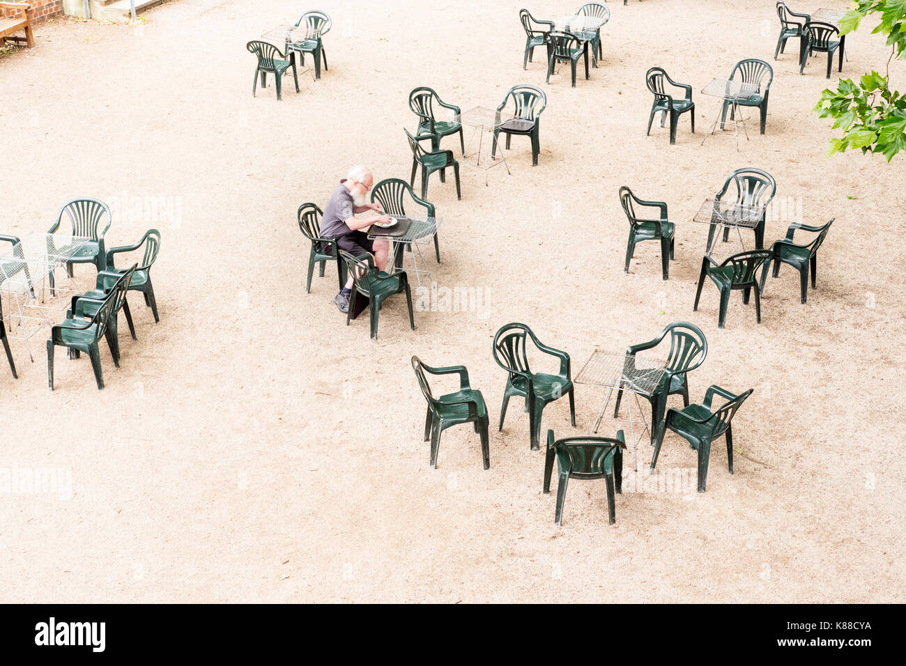 Ältere Menschen allein im Freien speisen im Cafe, Richmond, Großbritannien Stockfoto