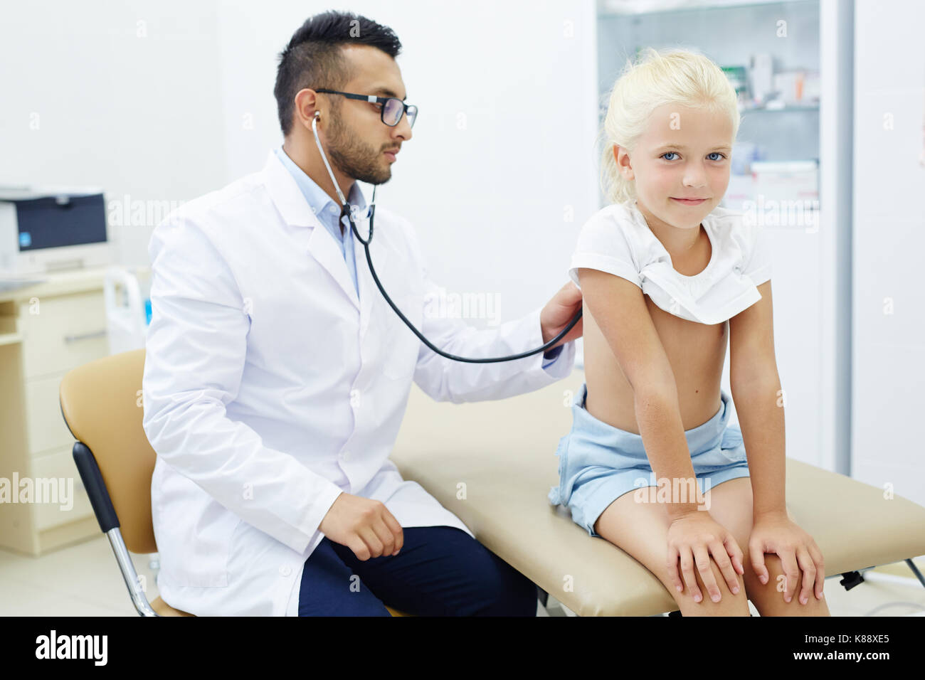 Kleines Mädchen Atmung während der medizinischen Behandlung in therapeutist Büro Stockfoto