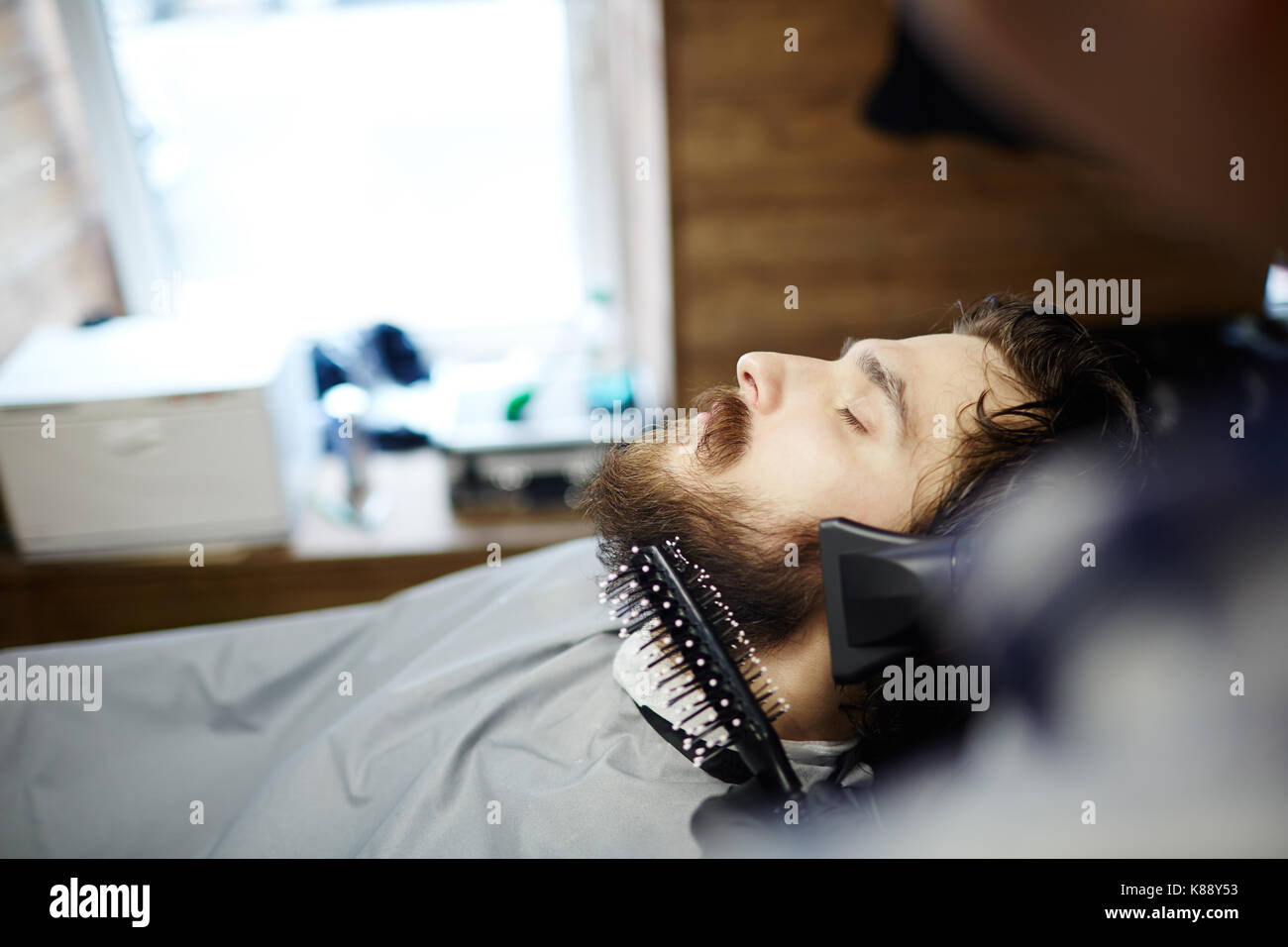 Friseur oder Friseur Putzen und trocknen client Haar und Bart in Salon Stockfoto