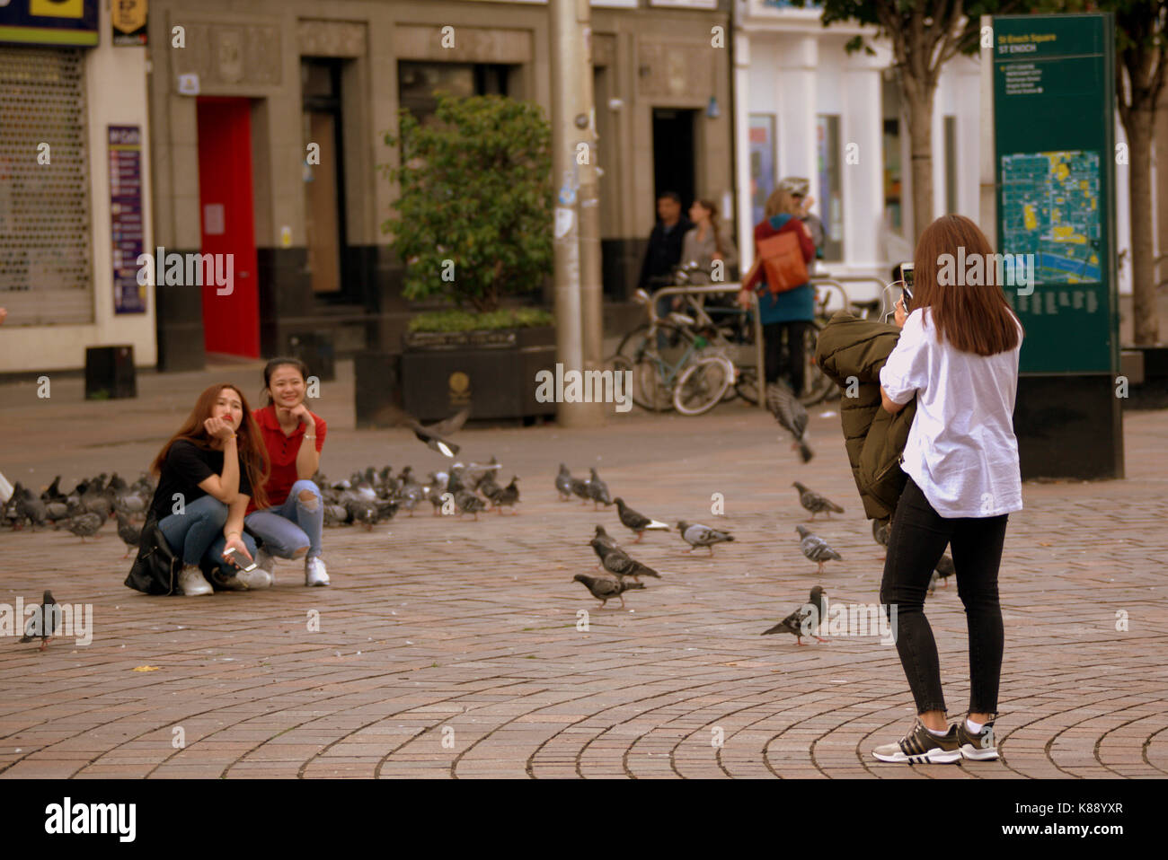 Drei 3 chinesische Frauen Mädchen Nehmen selfies mit Tauben in St Enoch Square Glasgow Stockfoto
