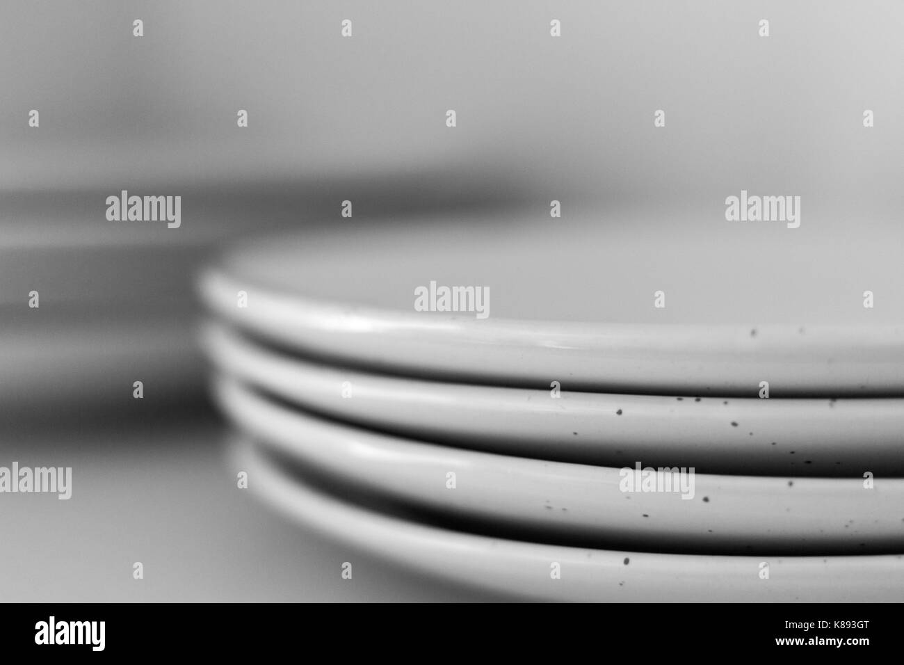 Nahaufnahme von einem Stapel weiße Platten in Schwarz und Weiß Stockfoto