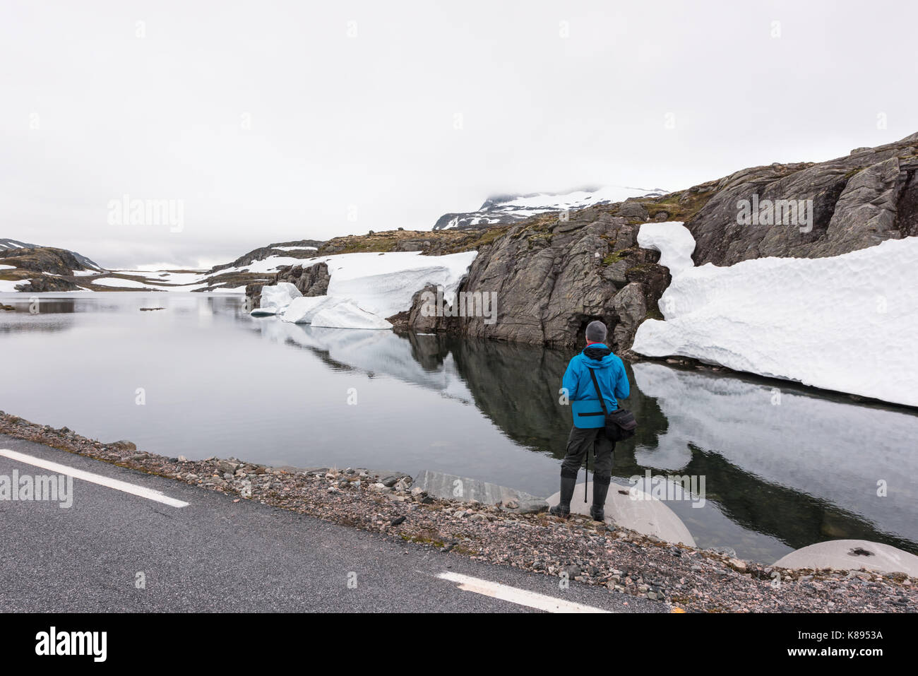 Fotograf, Foto, typisch norwegische Landschaft mit schneebedeckten Bergen und Clear Lake in der Nähe der berühmten Aurlandsvegen Mountain Road, Aurland, noch Stockfoto