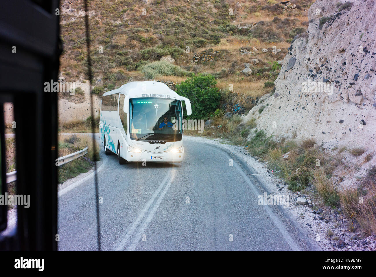 Local Bus mit Touristen zwischen Oia und Thera auf Santorini engen, gewundenen Straßen. Überfüllte Einrichtungen ist üblich. Stockfoto