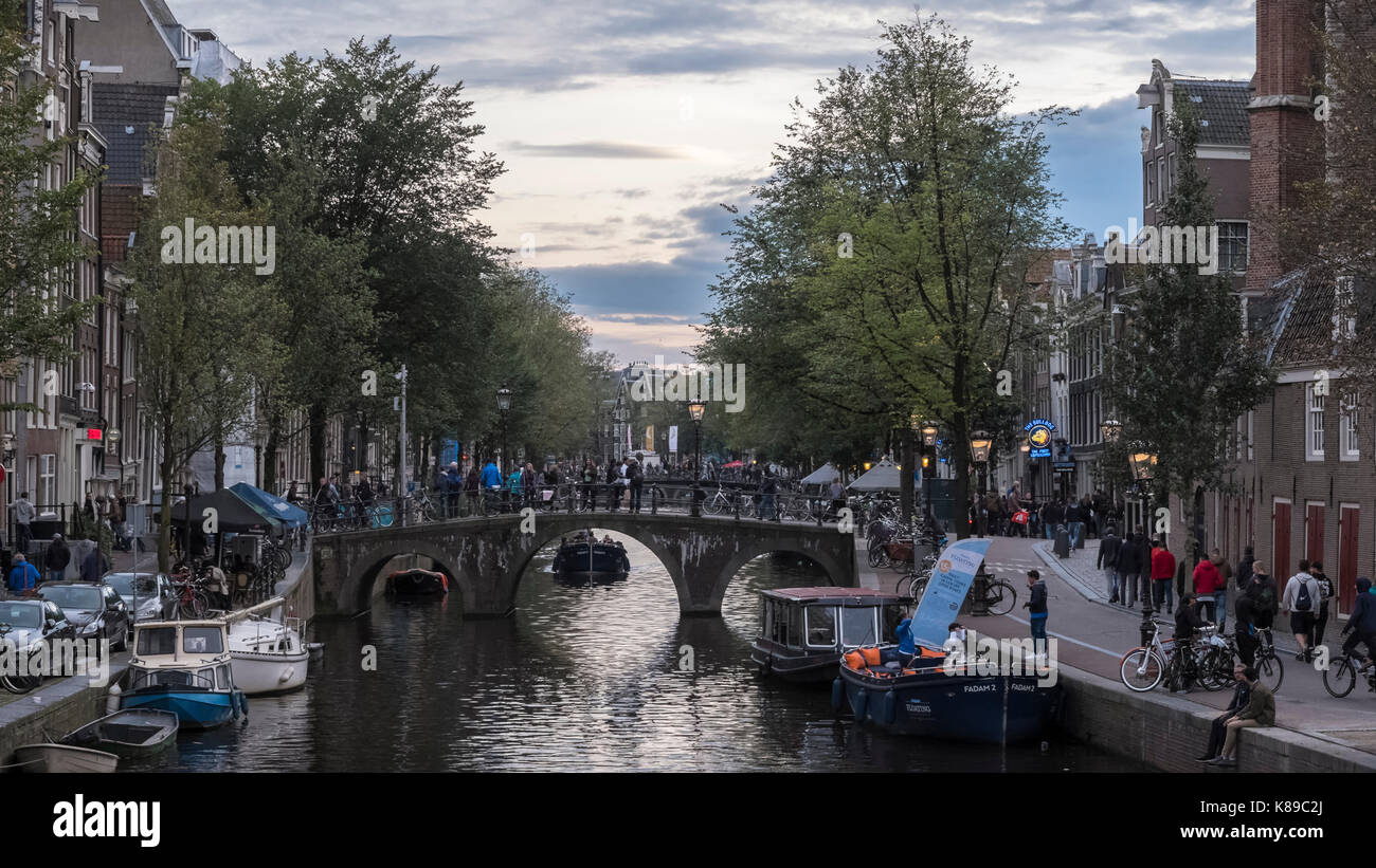 Eine lebhafte Kanal in Amsterdam, Niederlande, mit Touristen, um die Stadt zu erkunden. Stockfoto