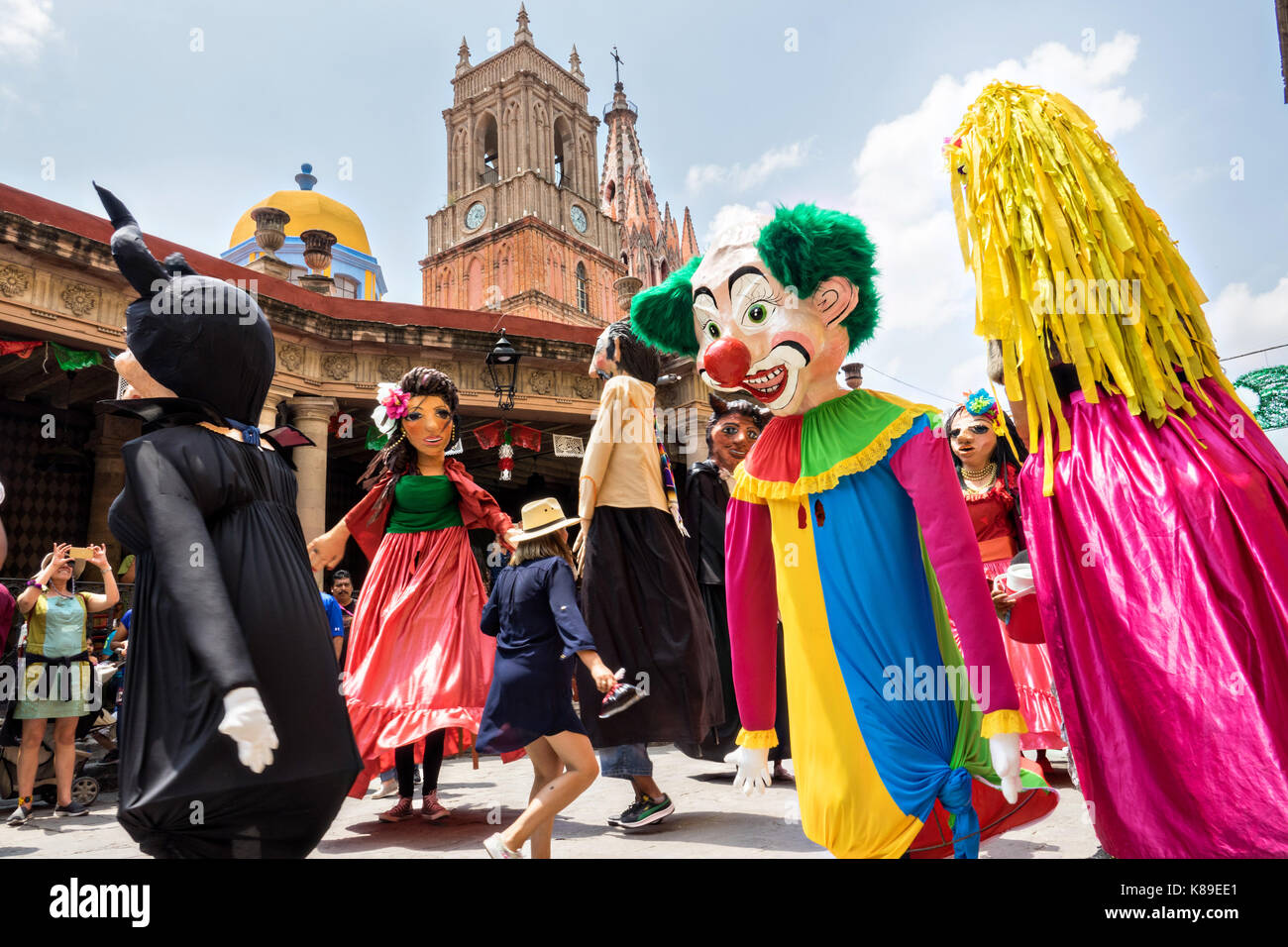 Riesige Pappmaché-Puppen namens Mojigangas tanzen vor der Kirche Parroquia de San Miguel Arcangel während einer Kinderparade, die den mexikanischen Unabhängigkeitstag feiert 17. September 2017 in San Miguel de Allende, Mexiko. Stockfoto