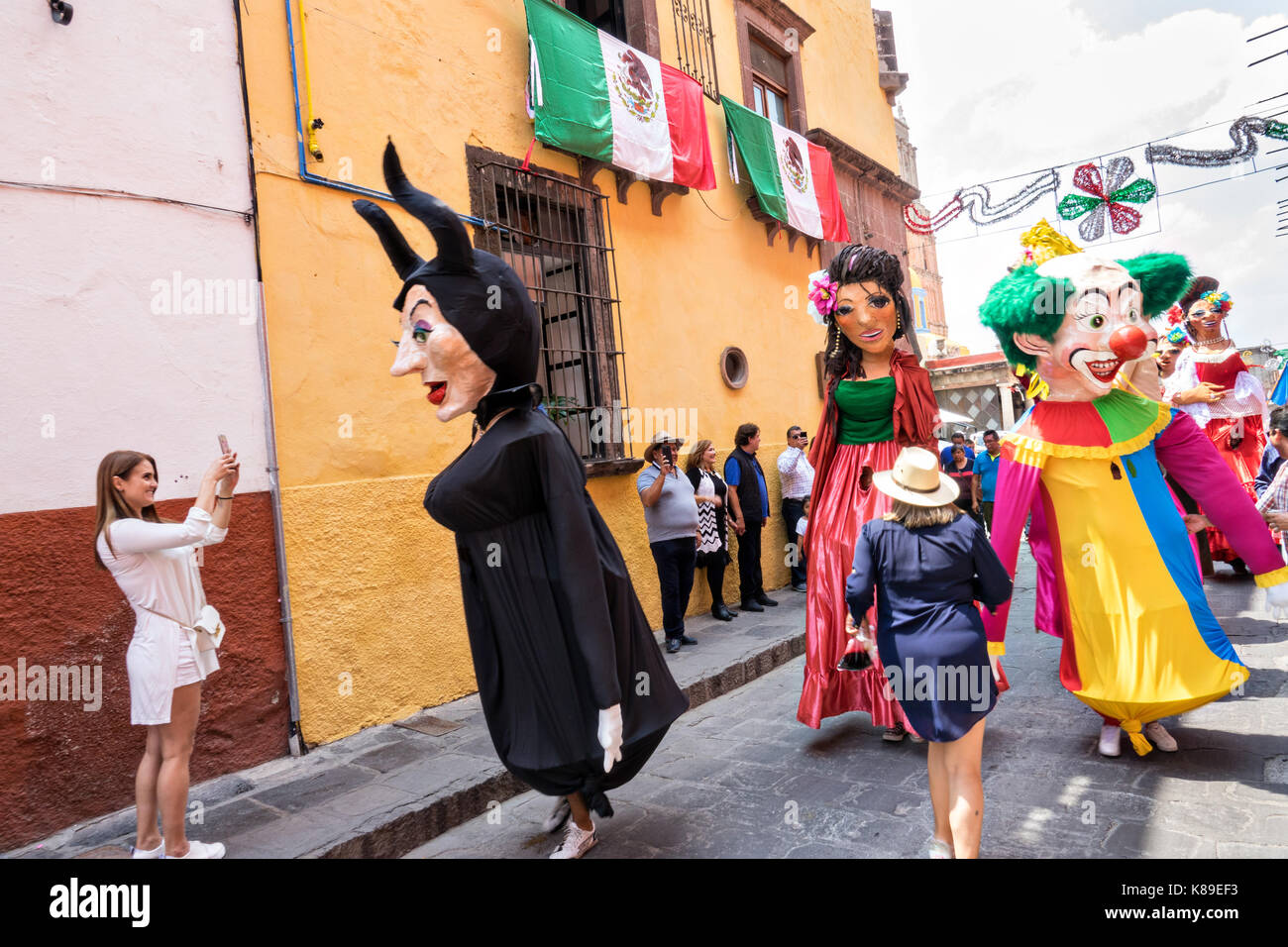 Riesige Pappmaché-Puppen namens Mojigangas tanzen in den Straßen während einer Kinderparade, die die Feierlichkeiten zum mexikanischen Unabhängigkeitstag am 17. September 2017 in San Miguel de Allende, Mexiko, feiert. Stockfoto