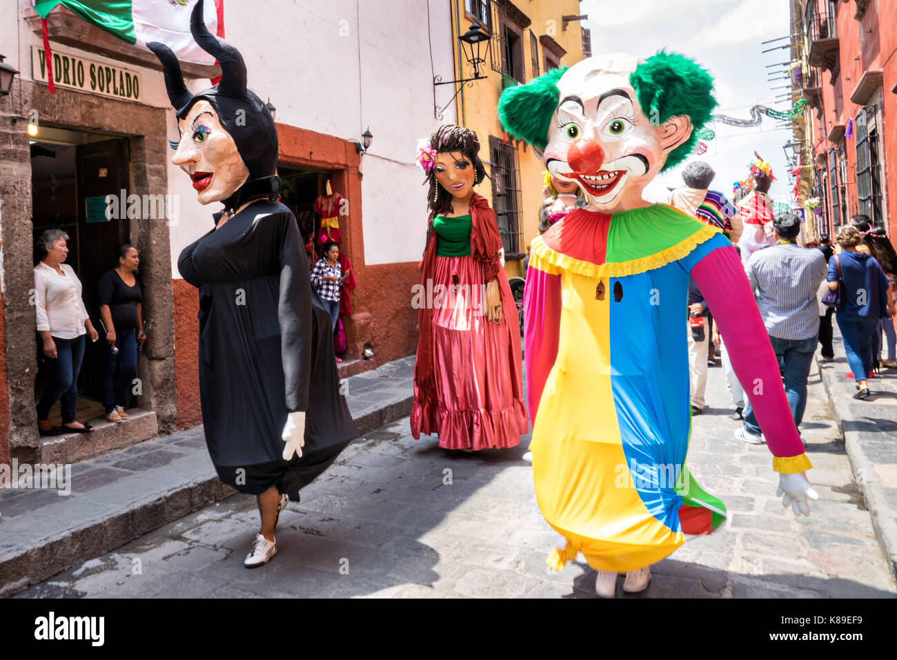 Riesige Pappmaché-Puppen namens Mojigangas tanzen in den Straßen während einer Kinderparade, die die Feierlichkeiten zum mexikanischen Unabhängigkeitstag am 17. September 2017 in San Miguel de Allende, Mexiko, feiert. Stockfoto