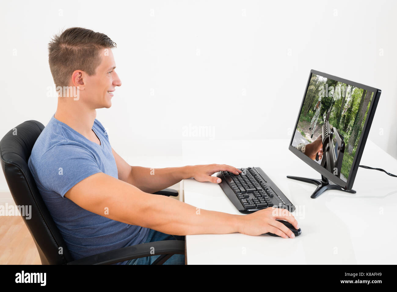 Glückliche Menschen, die Spiel auf dem Desktop Computer am Schreibtisch Stockfoto