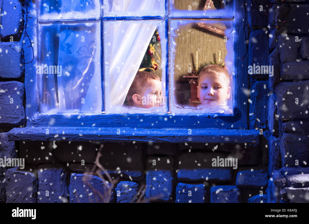 Kinder sehen von zu Hause über das Fenster während des sehr Zeit Stockfoto