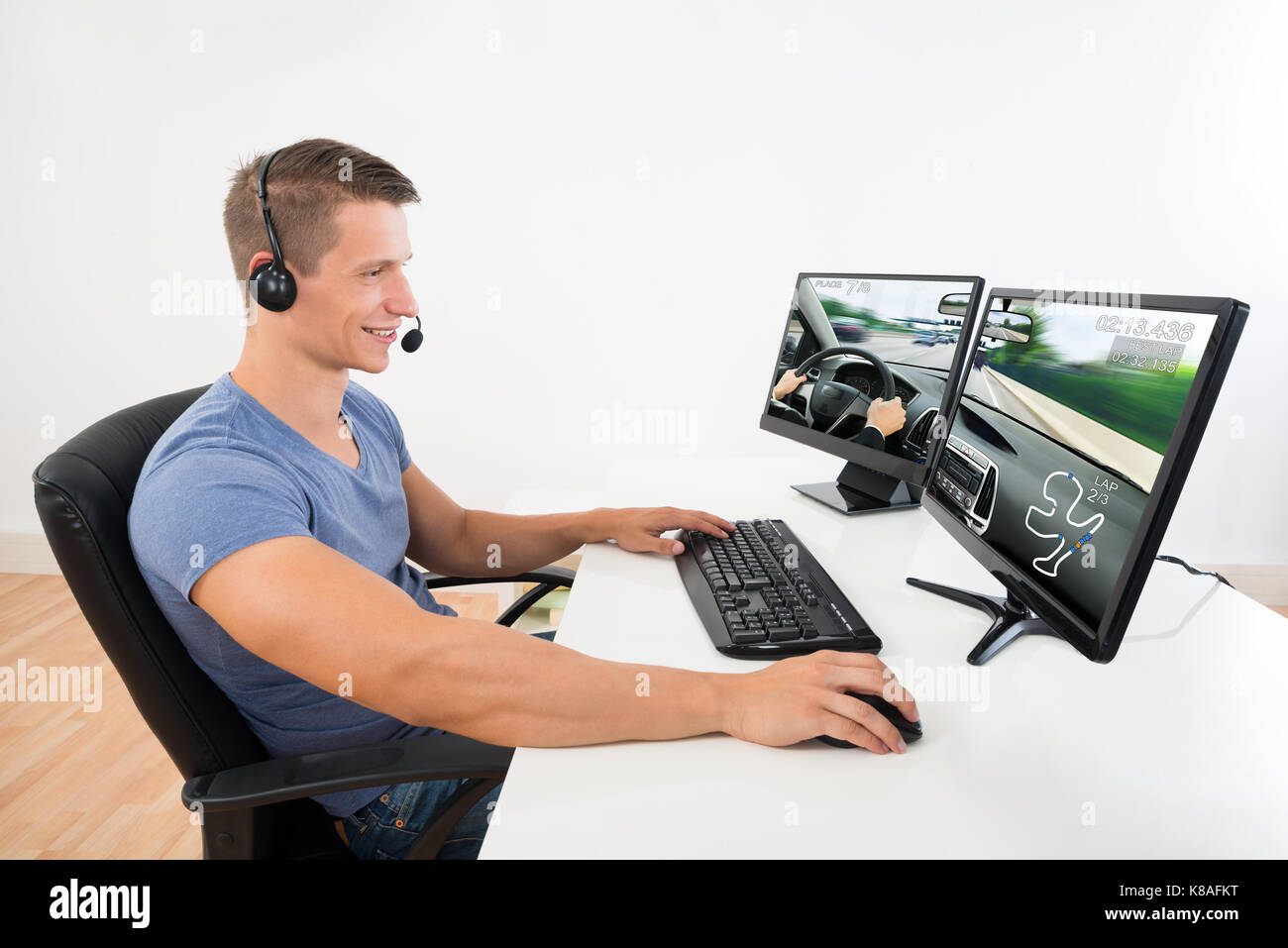 Young Man Playing Computer Game Stockfotos Young Man Playing - glucklicher mann mit headset spielen spiel auf desktop computer zu hause stockbild